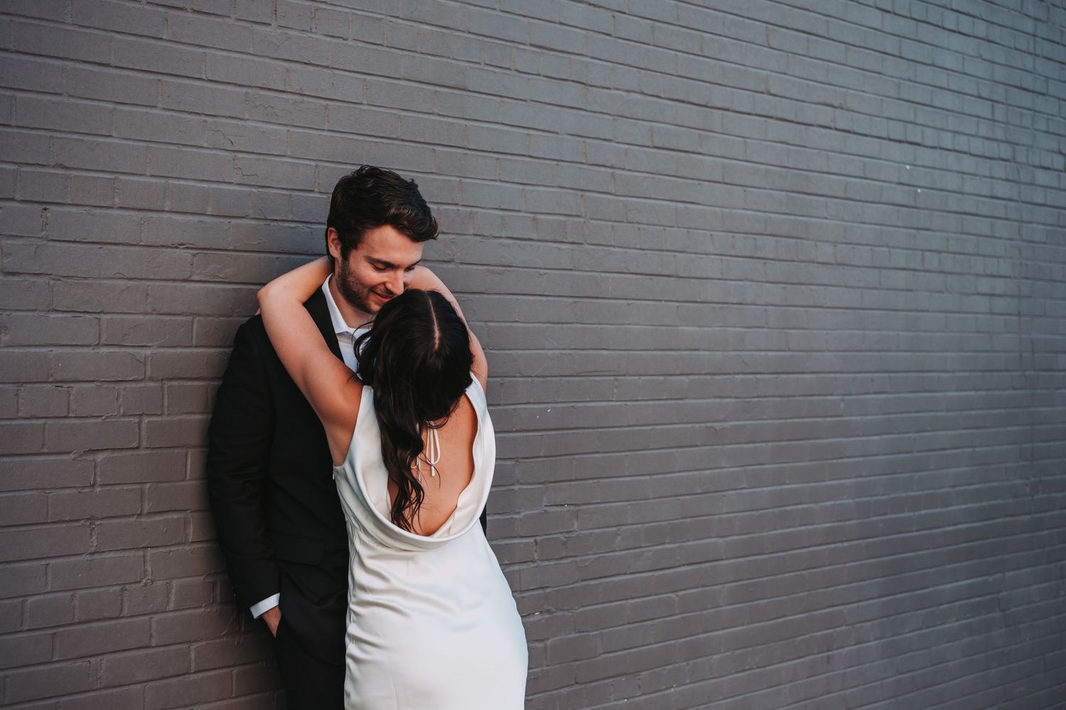 Urban wedding photos against a grey brick wall background.