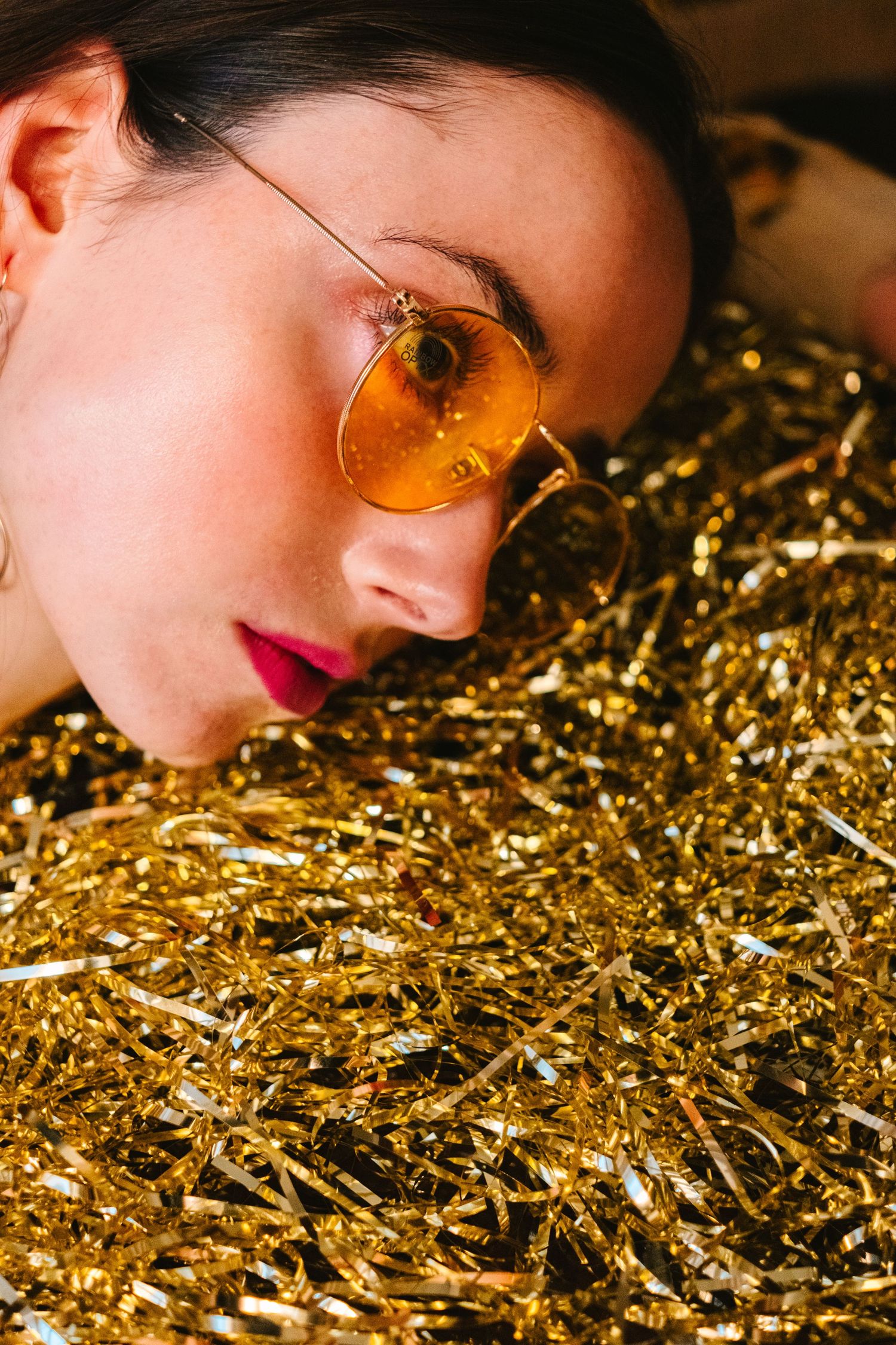 Close-up portrait with gold glitter creating a sparkling artistic effect.