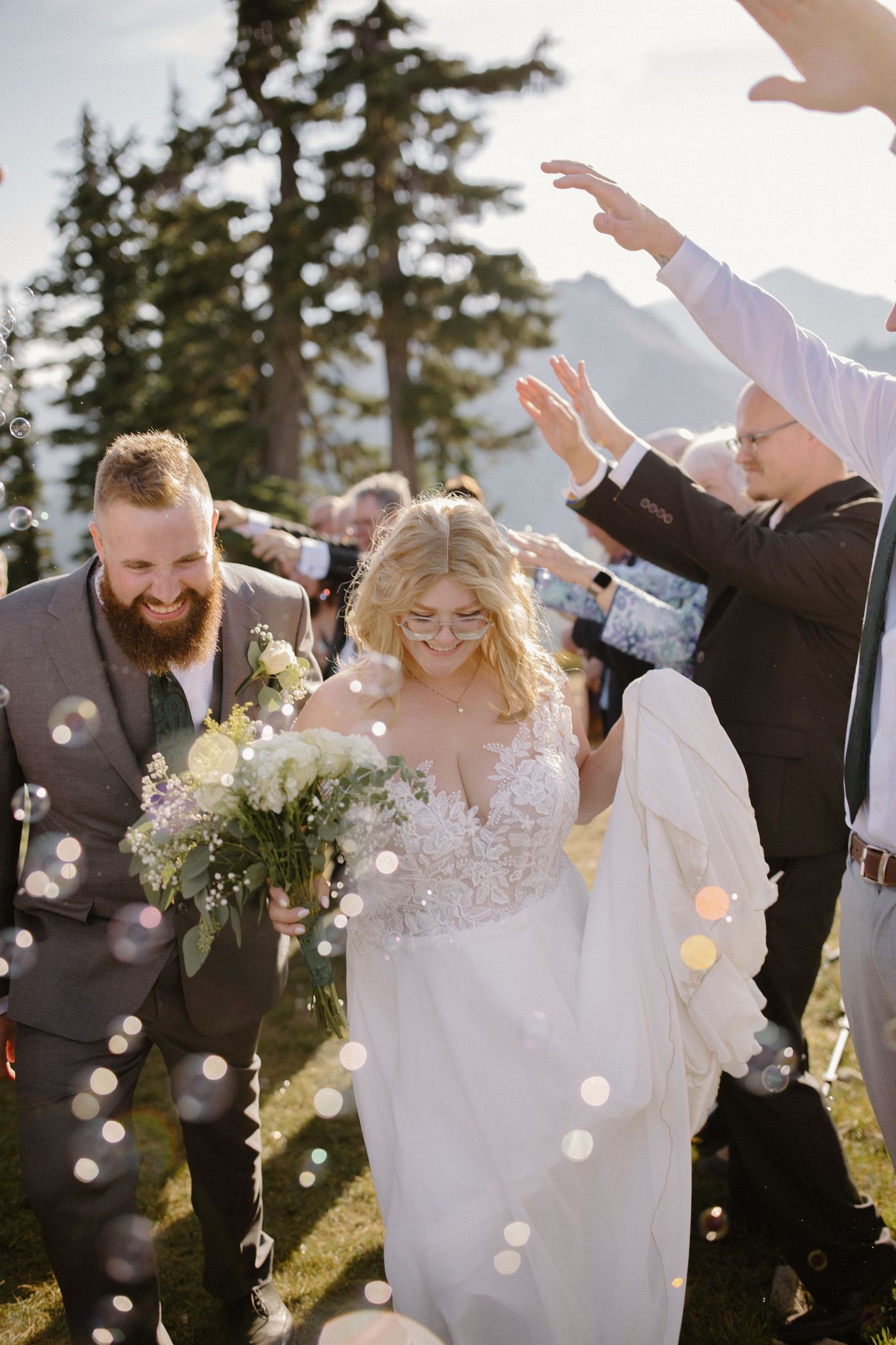 Wedding celebration with confetti being thrown against a mountain backdrop at sunset.