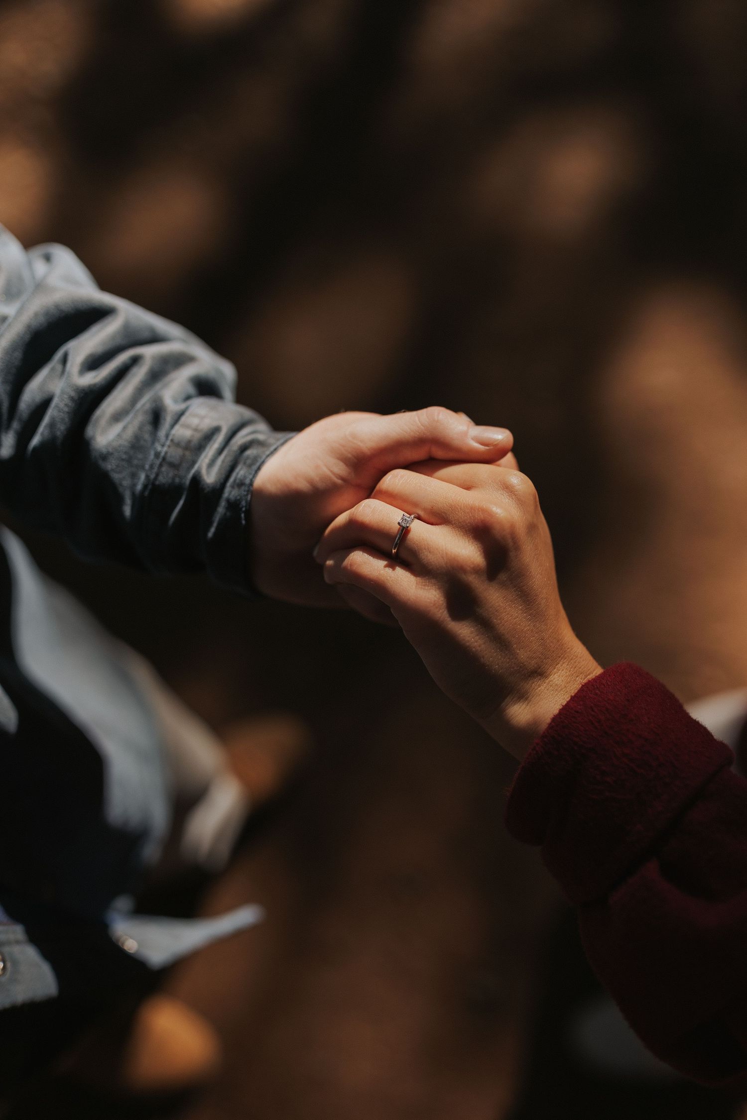 Close-up of two hands joining together in a gentle hold.