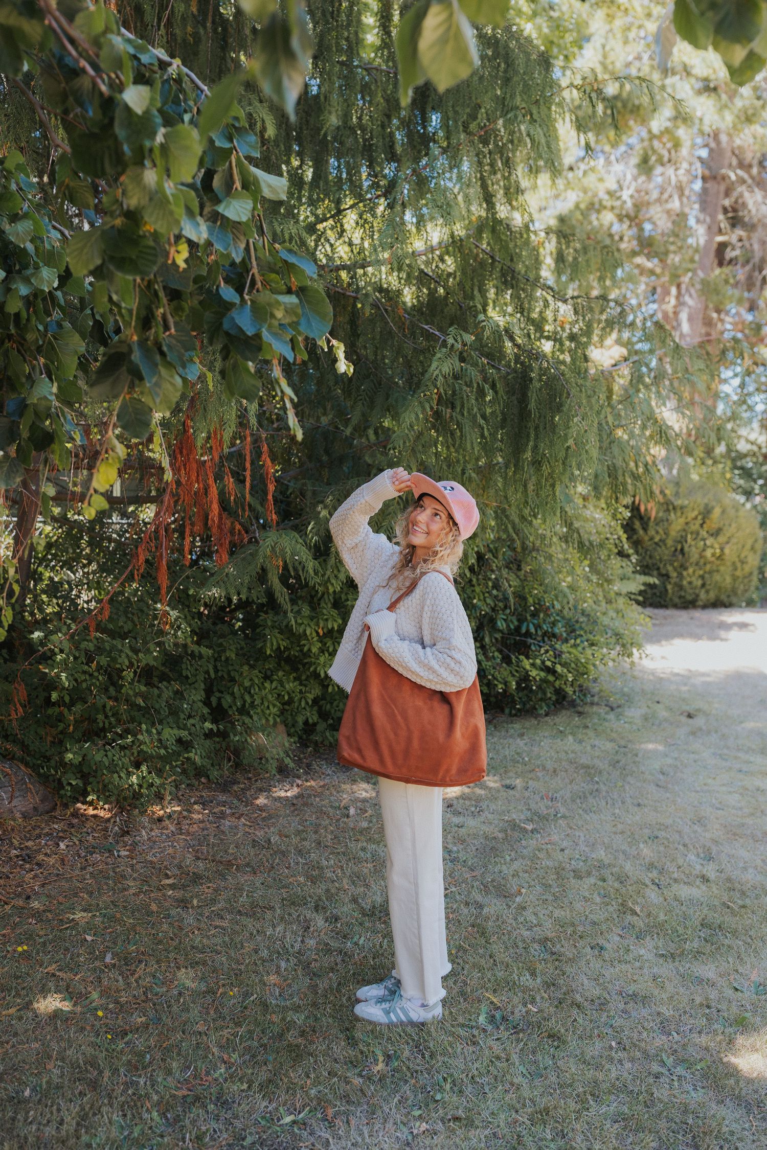 A series of outdoor fashion shots featuring white clothing and an orange tote bag.