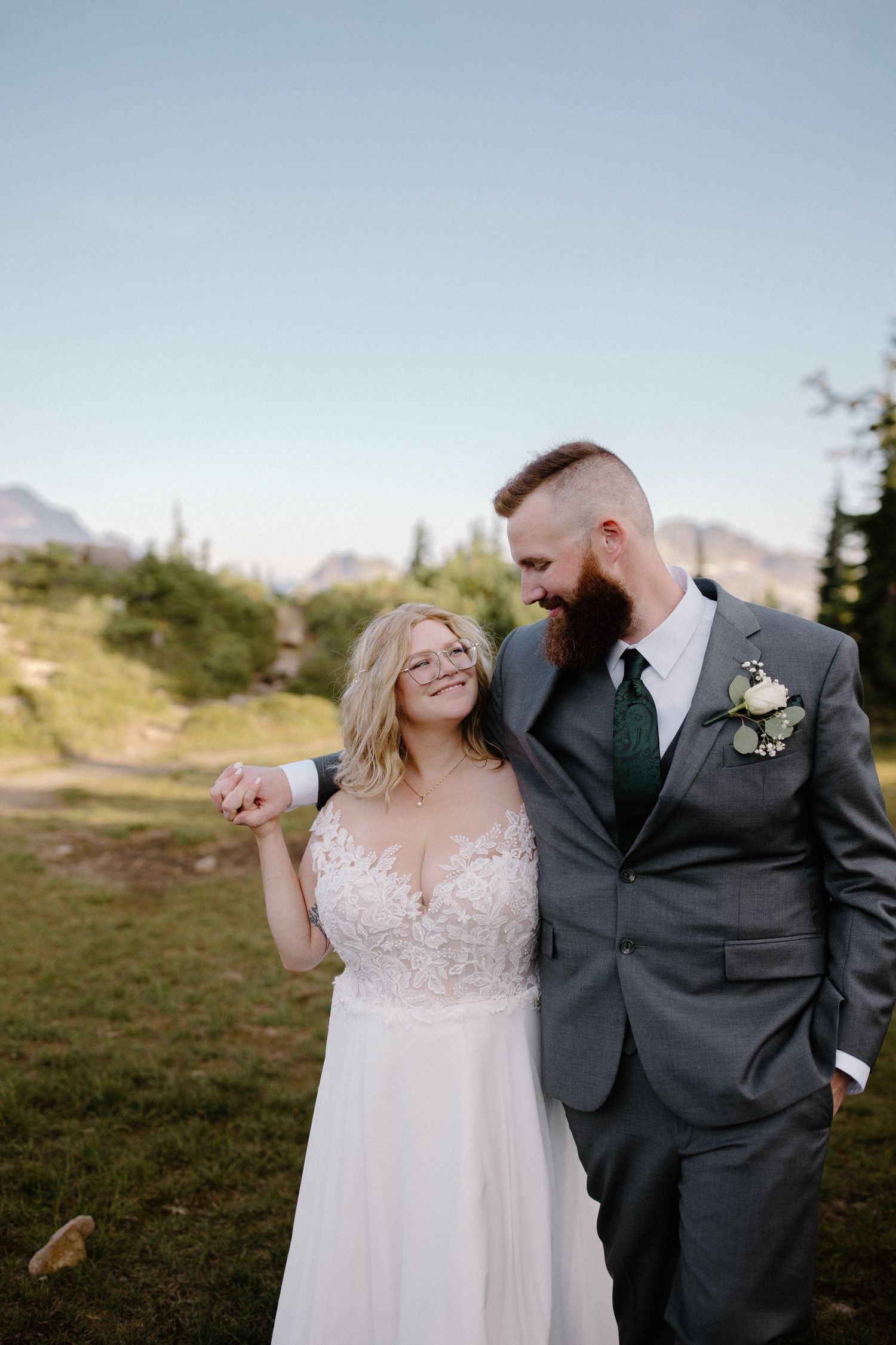 A joyful wedding moment shared against a mountain landscape with clear blue skies.