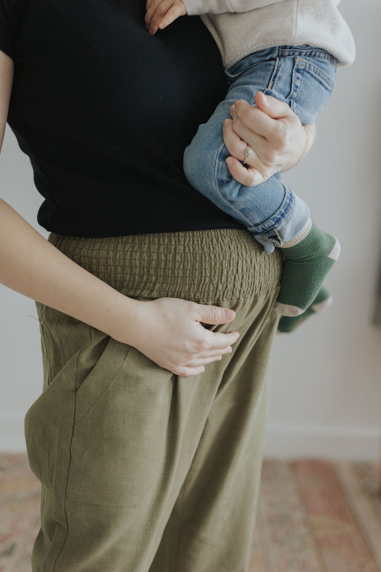 Close-up of olive green pants with elastic waistband detail.