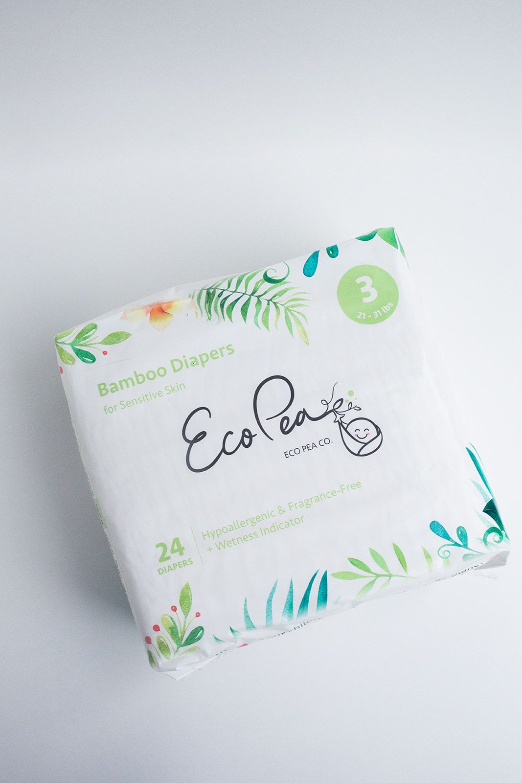 White bamboo diaper package with green botanical design elements on light background.