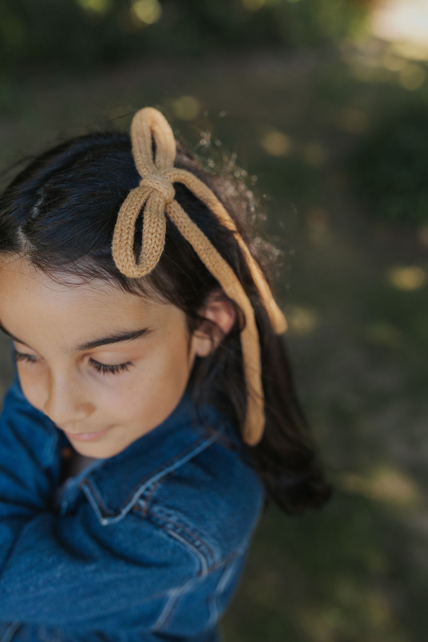 Close-up of a blue denim outfit with a beige headband accessory.