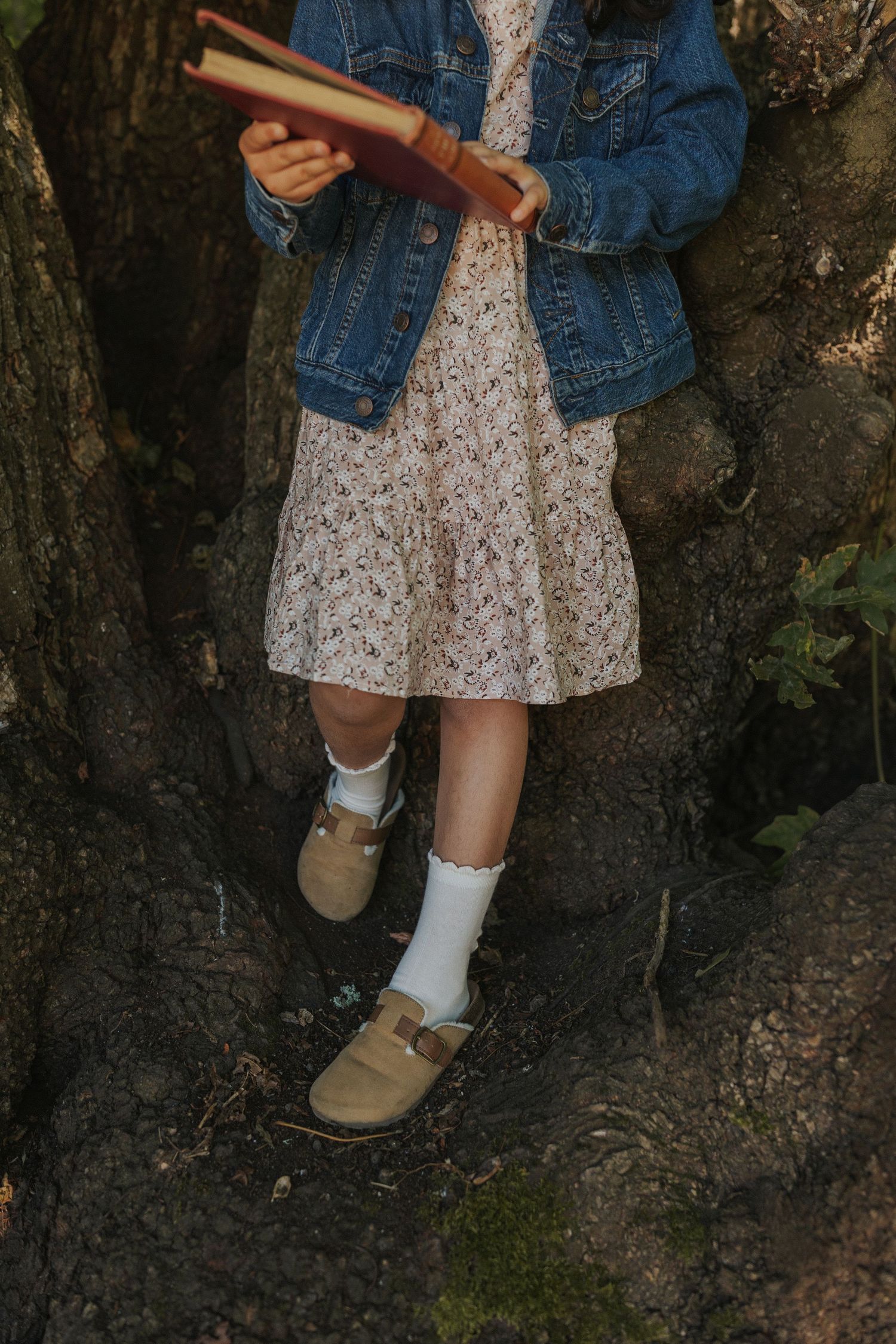 Detail shots of floral dress and denim jacket against tree bark texture.