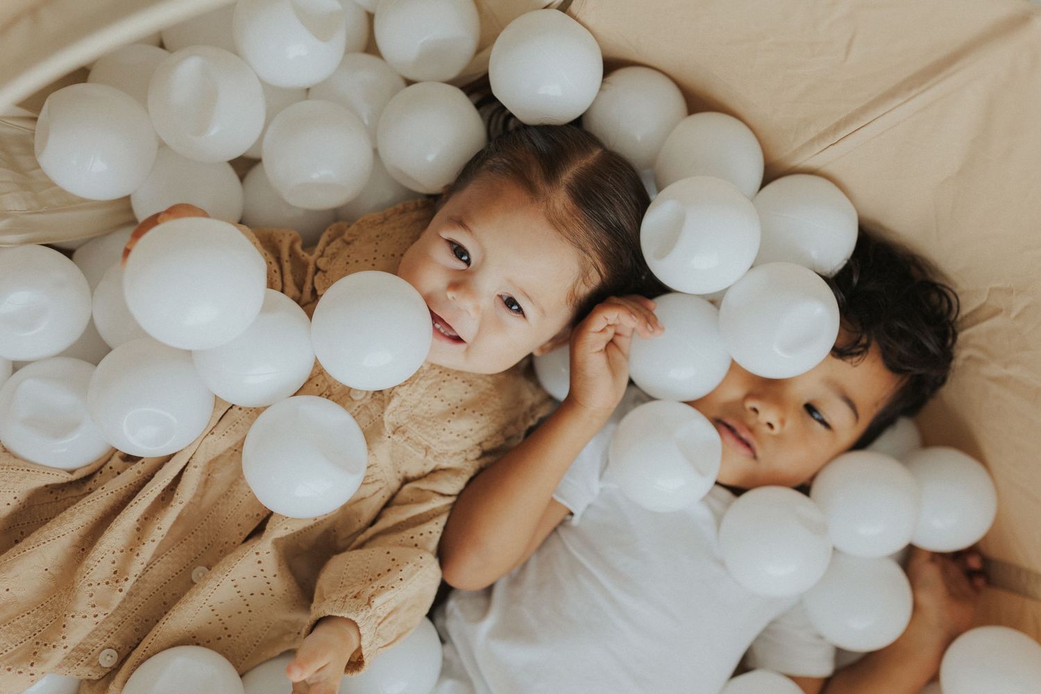 A cozy scene with white decorative balls arranged on a neutral-colored surface.