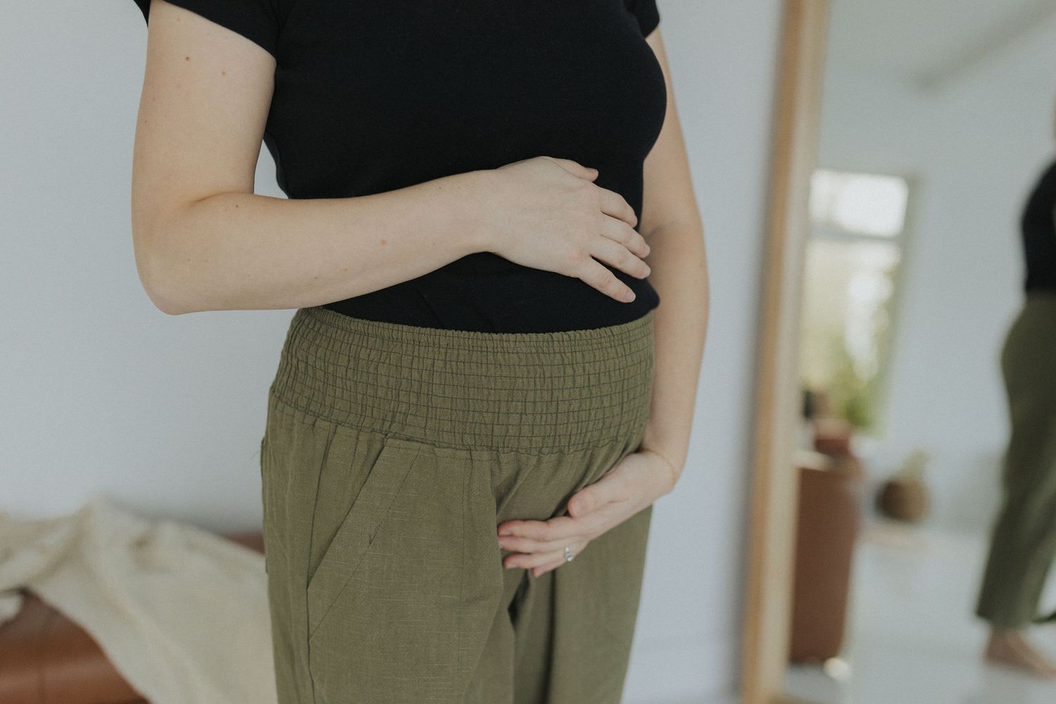 Detail shots of olive green pants with pockets and elastic waist.