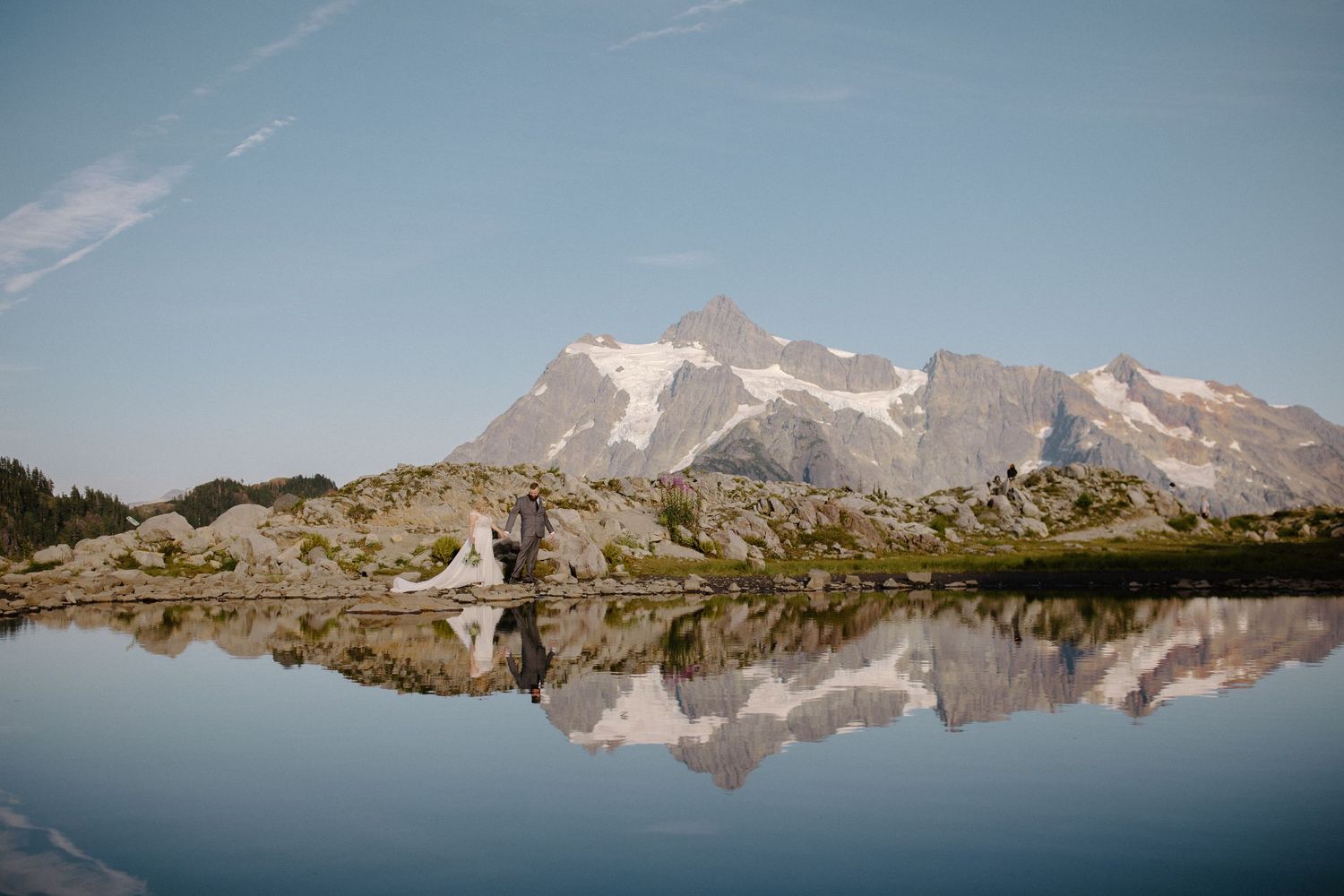 Stunning mountain landscape reflected in alpine lake during wedding shoot.