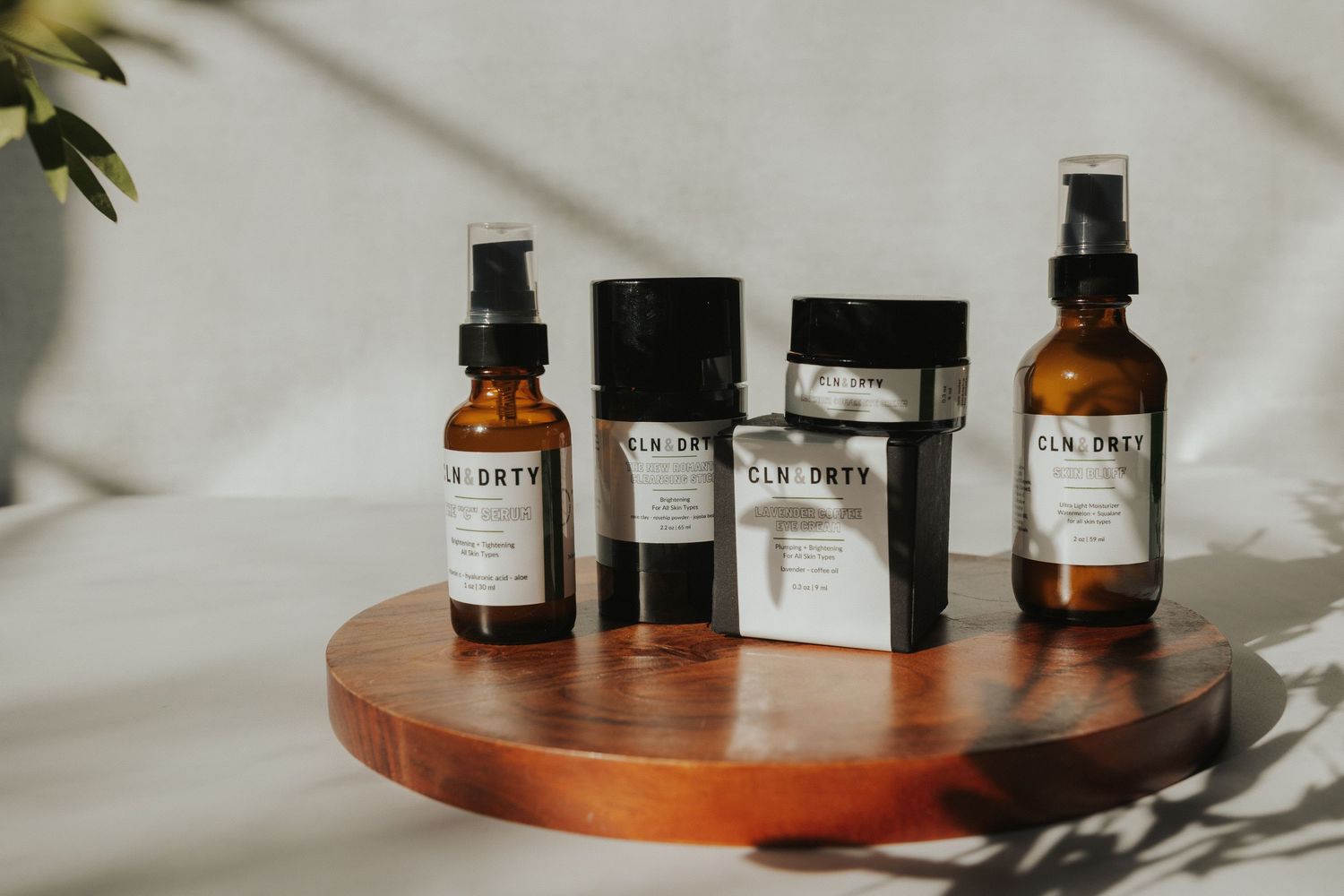 Collection of amber glass bottles and skincare products arranged on wooden surface.