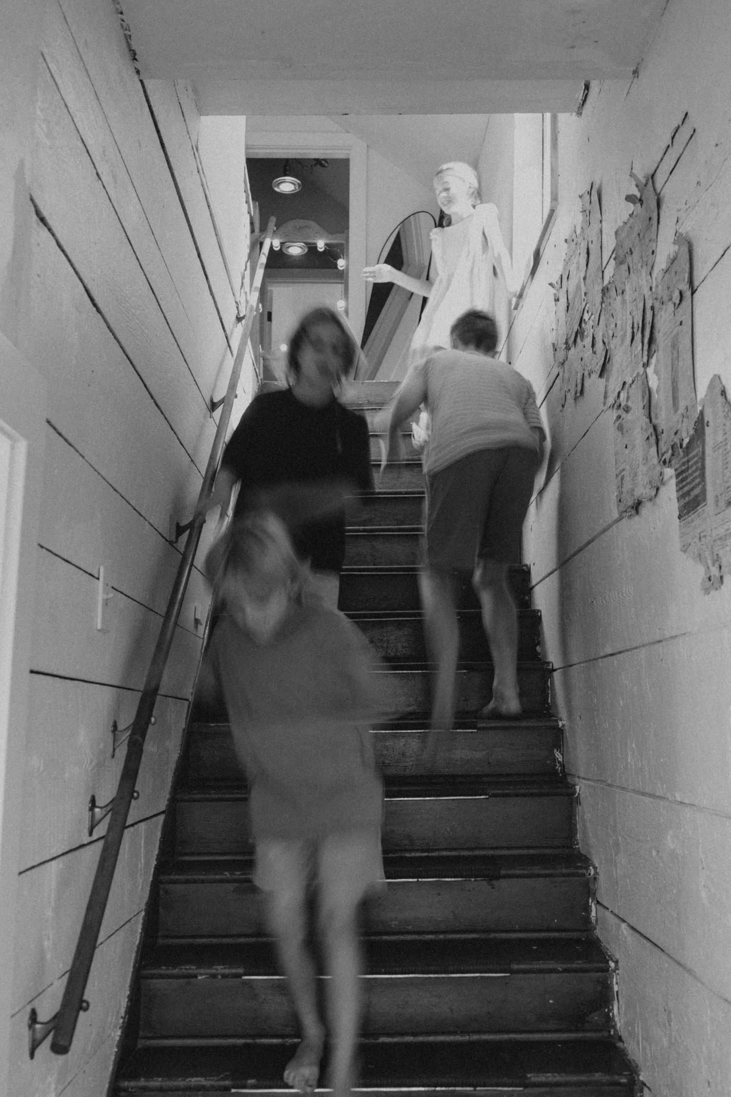 Blurred motion of people walking up white painted stairs.