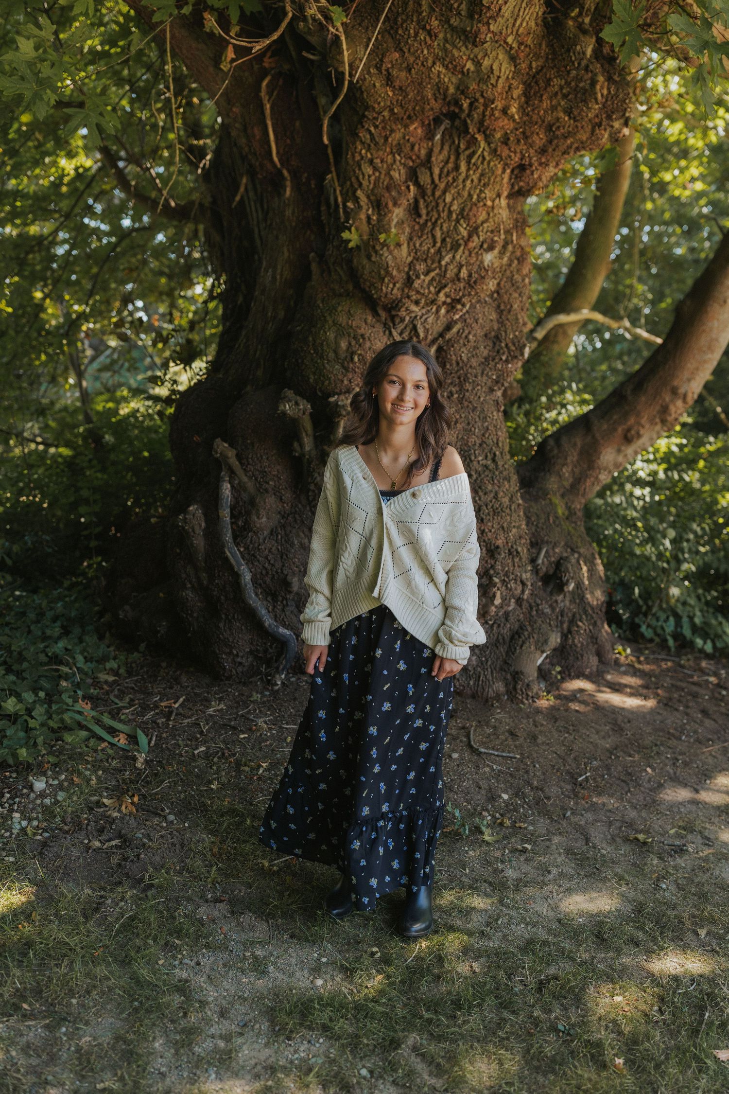 A dreamy autumn scene under a large tree with scattered light filtering through the leaves.