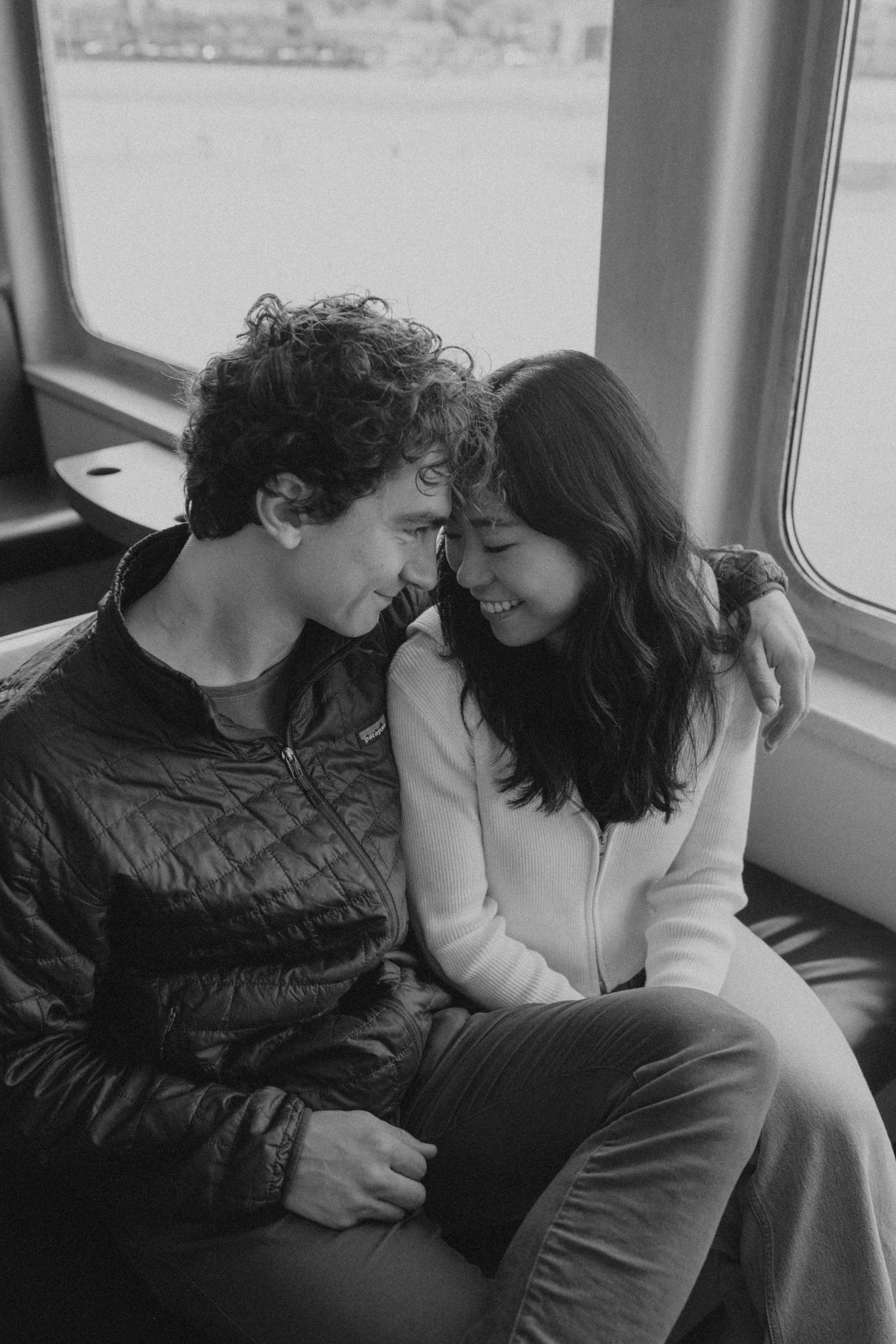 A tender black and white moment shared between a couple sitting close together.