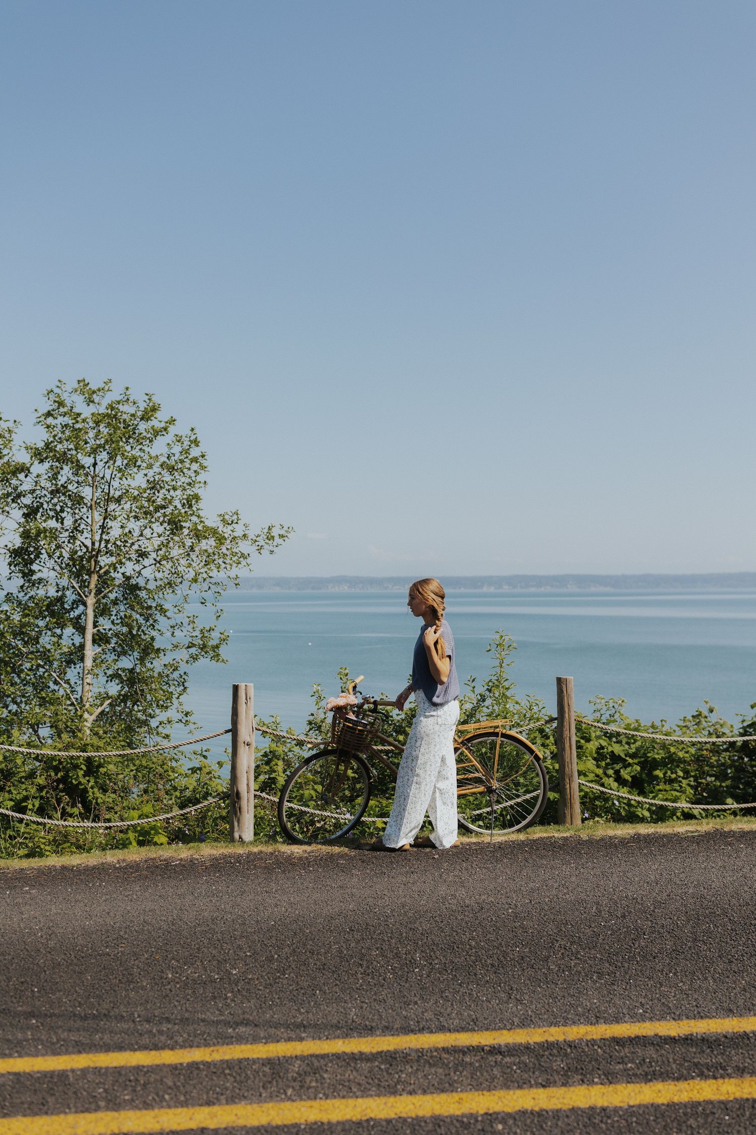 Scenic coastal view with bicycle silhouetted against blue ocean.