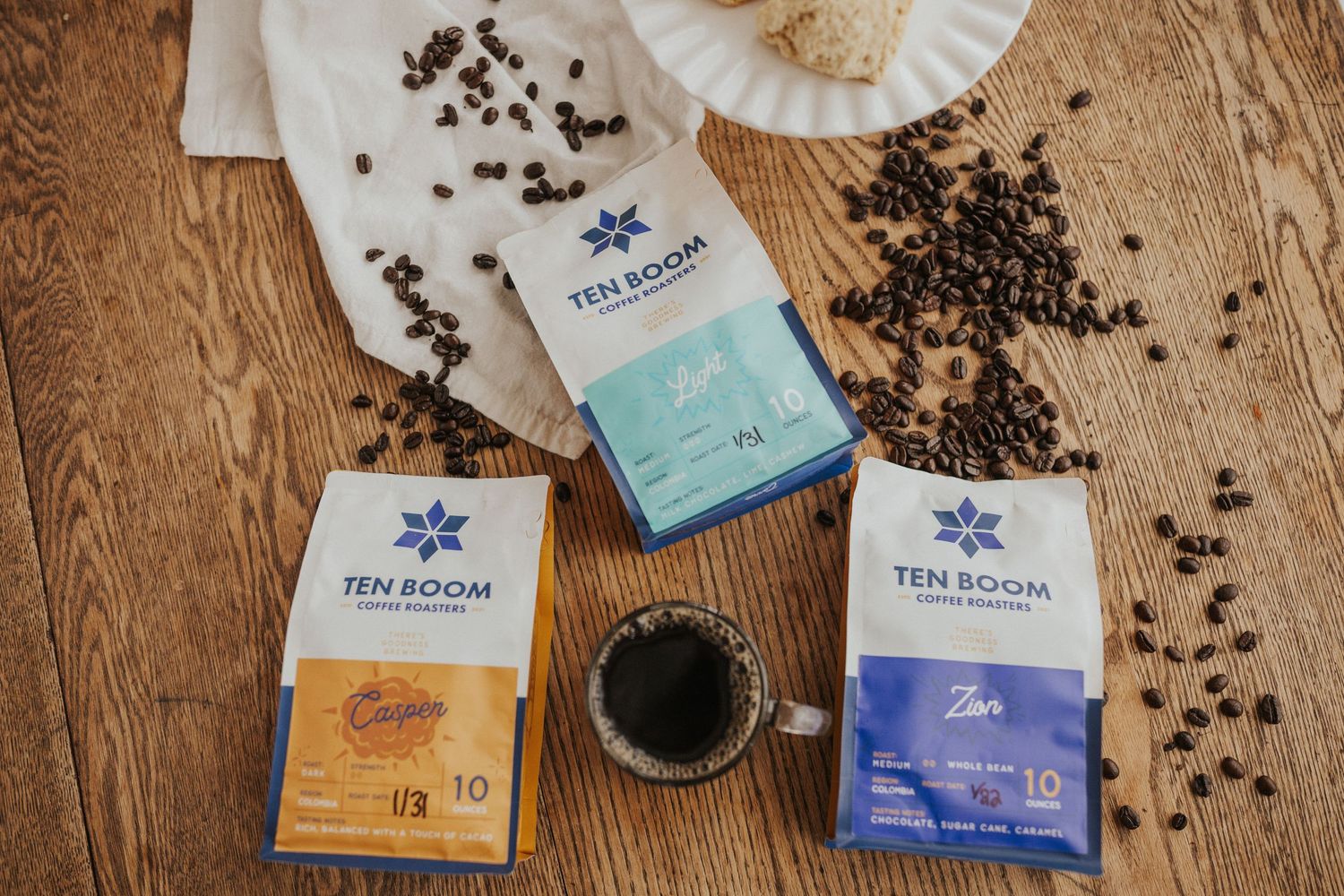 Tea room products and loose coffee beans scattered on wooden surface.