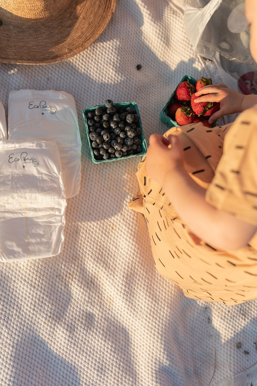 Fresh berries being arranged on white textured surface with pastry.