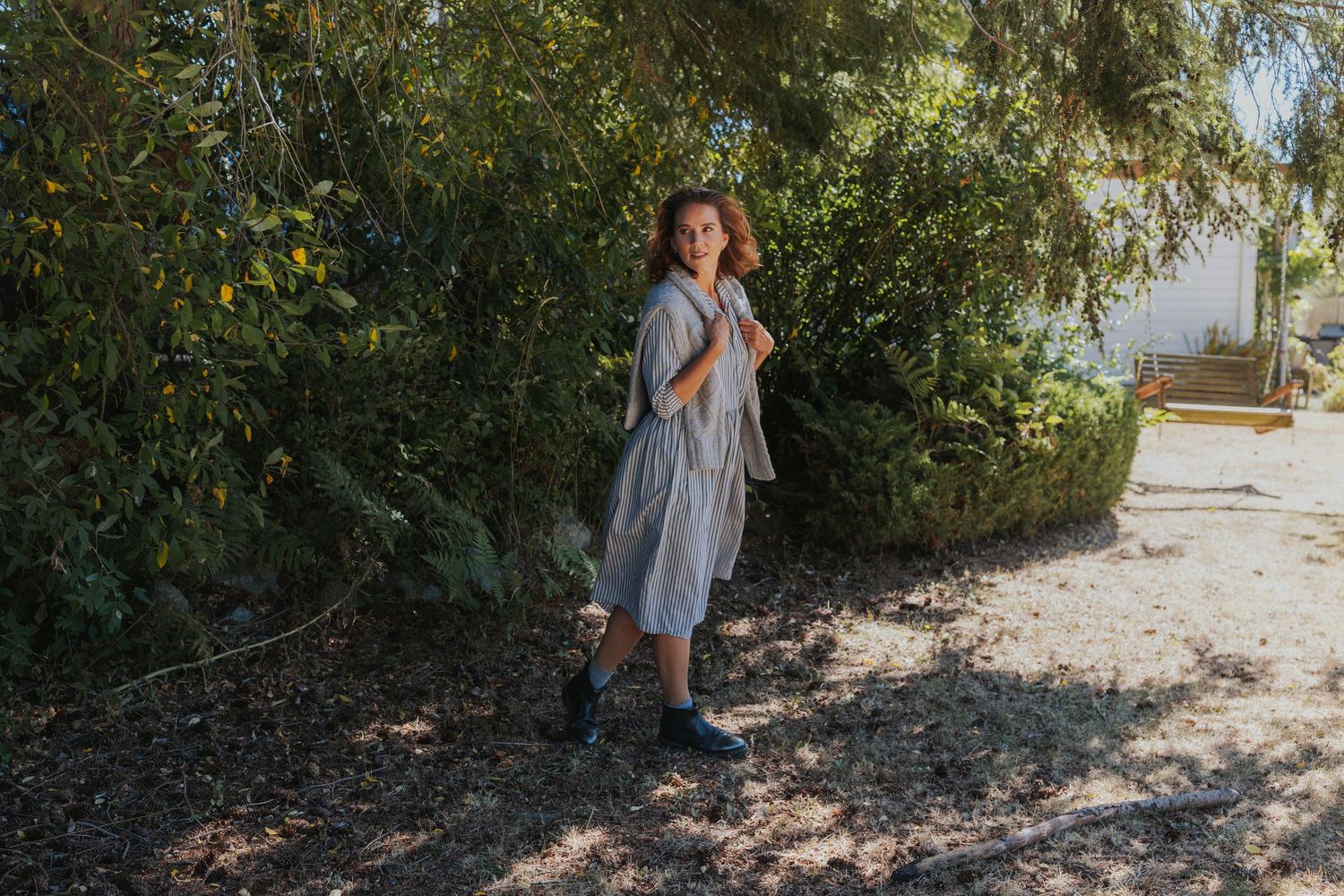 An artistic outdoor portrait session with natural sunlight filtering through trees.