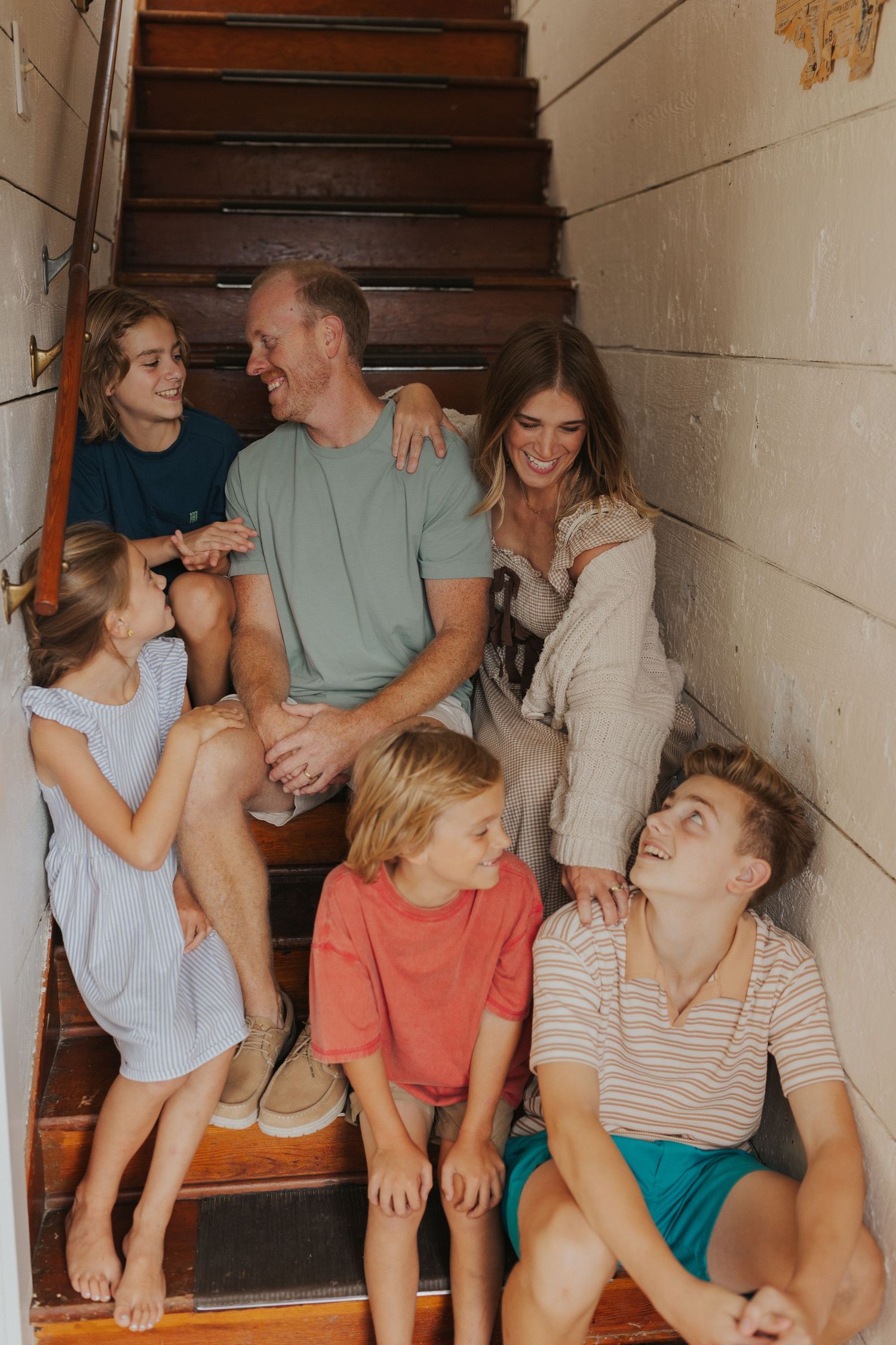 Group sitting together on indoor stairs sharing candid moments.