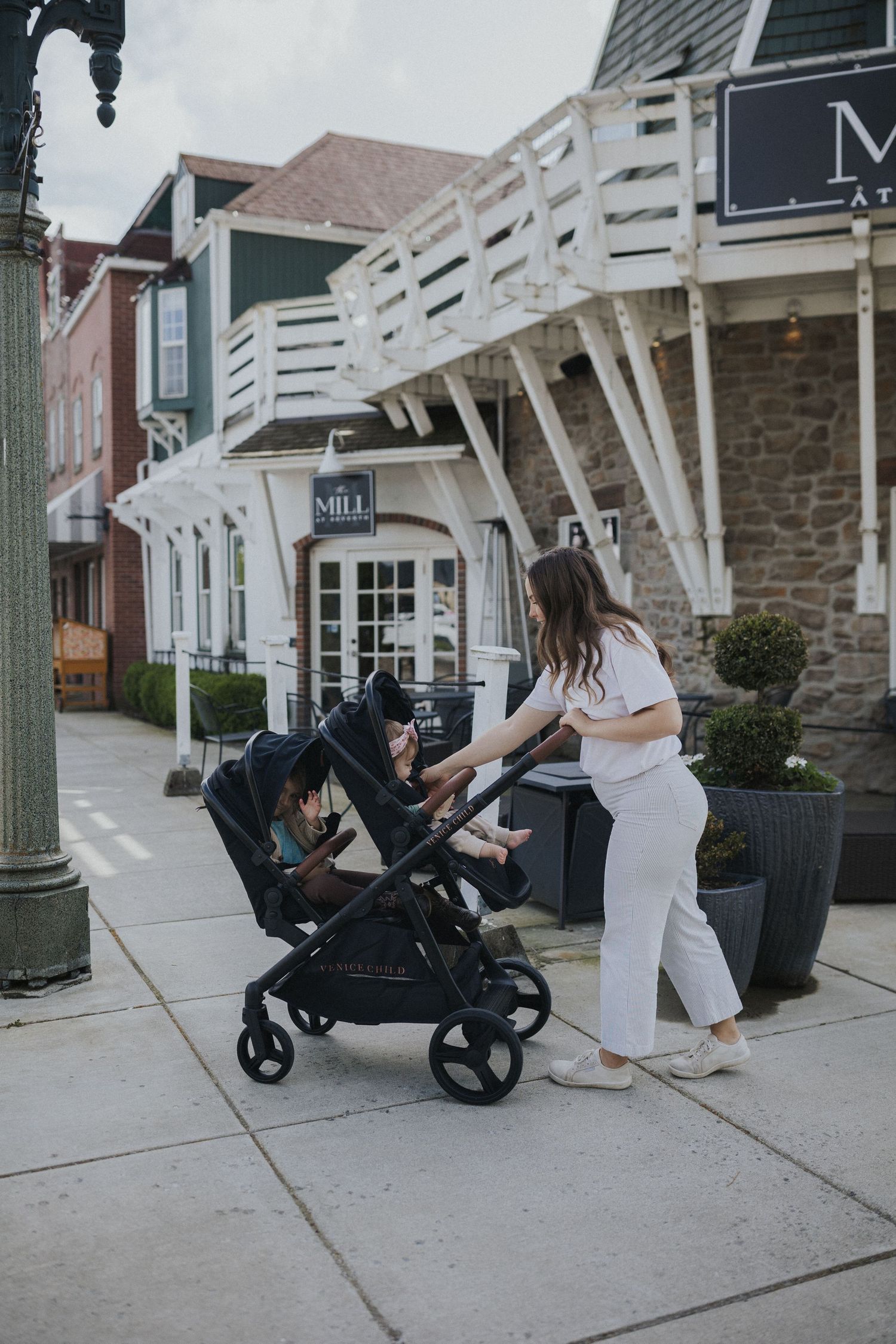 A series of photos showing a stroller being folded and unfolded on a sidewalk near stone buildings.