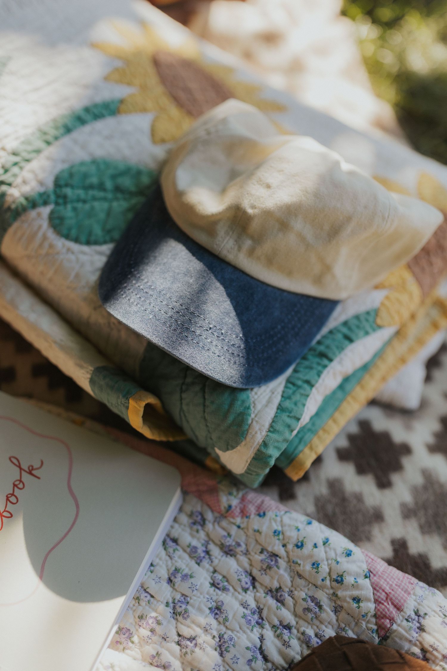 Neatly folded textiles and fabrics with delicate patterns displayed on a patterned surface.