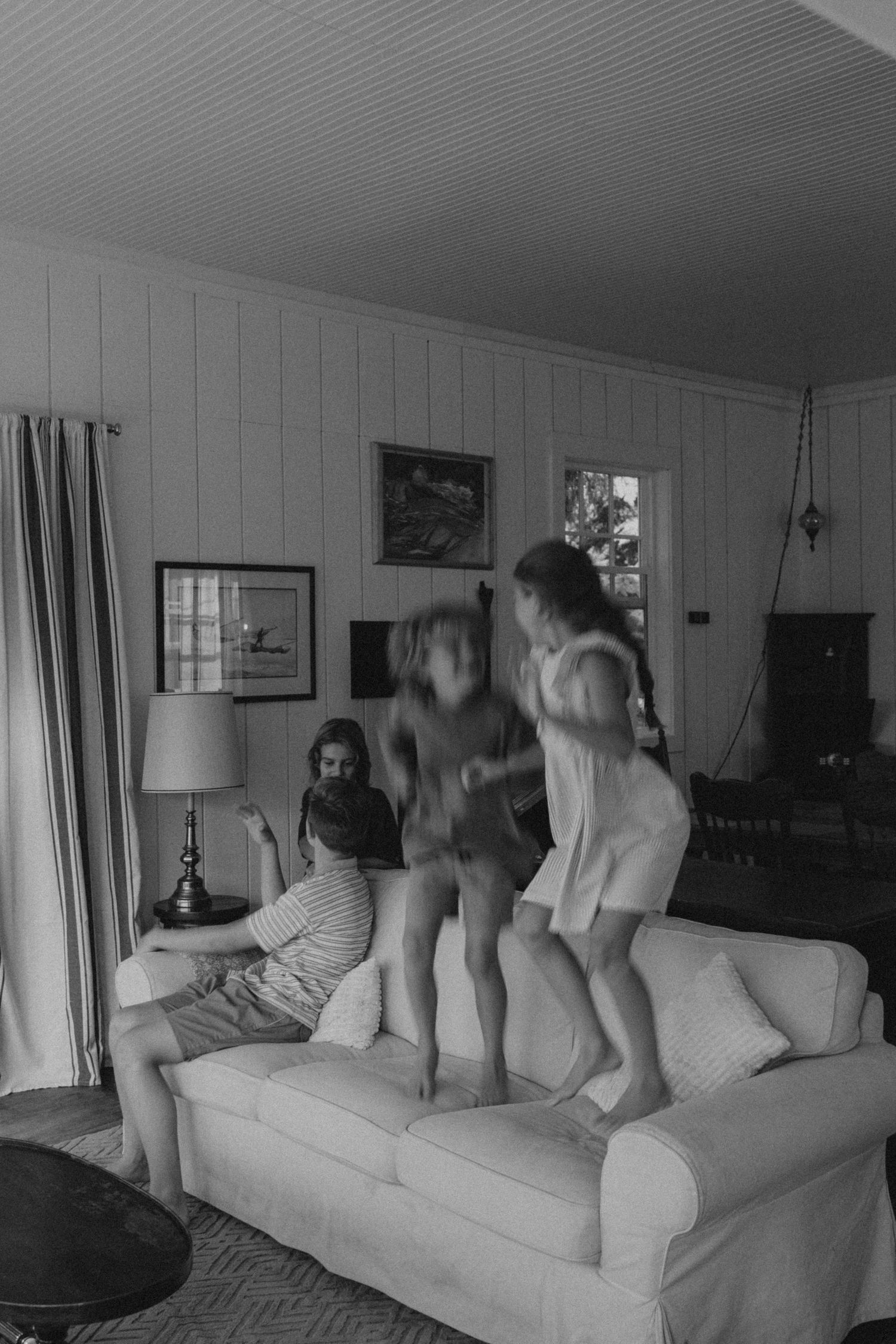 Black and white photo of energetic movement on a living room couch.