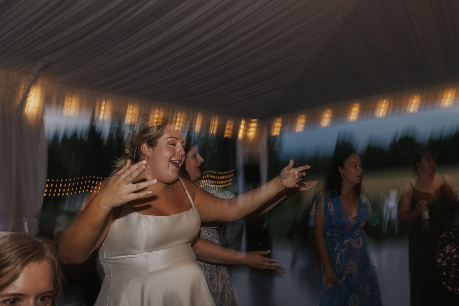 Wedding reception dance floor with string lights creating a festive atmosphere.