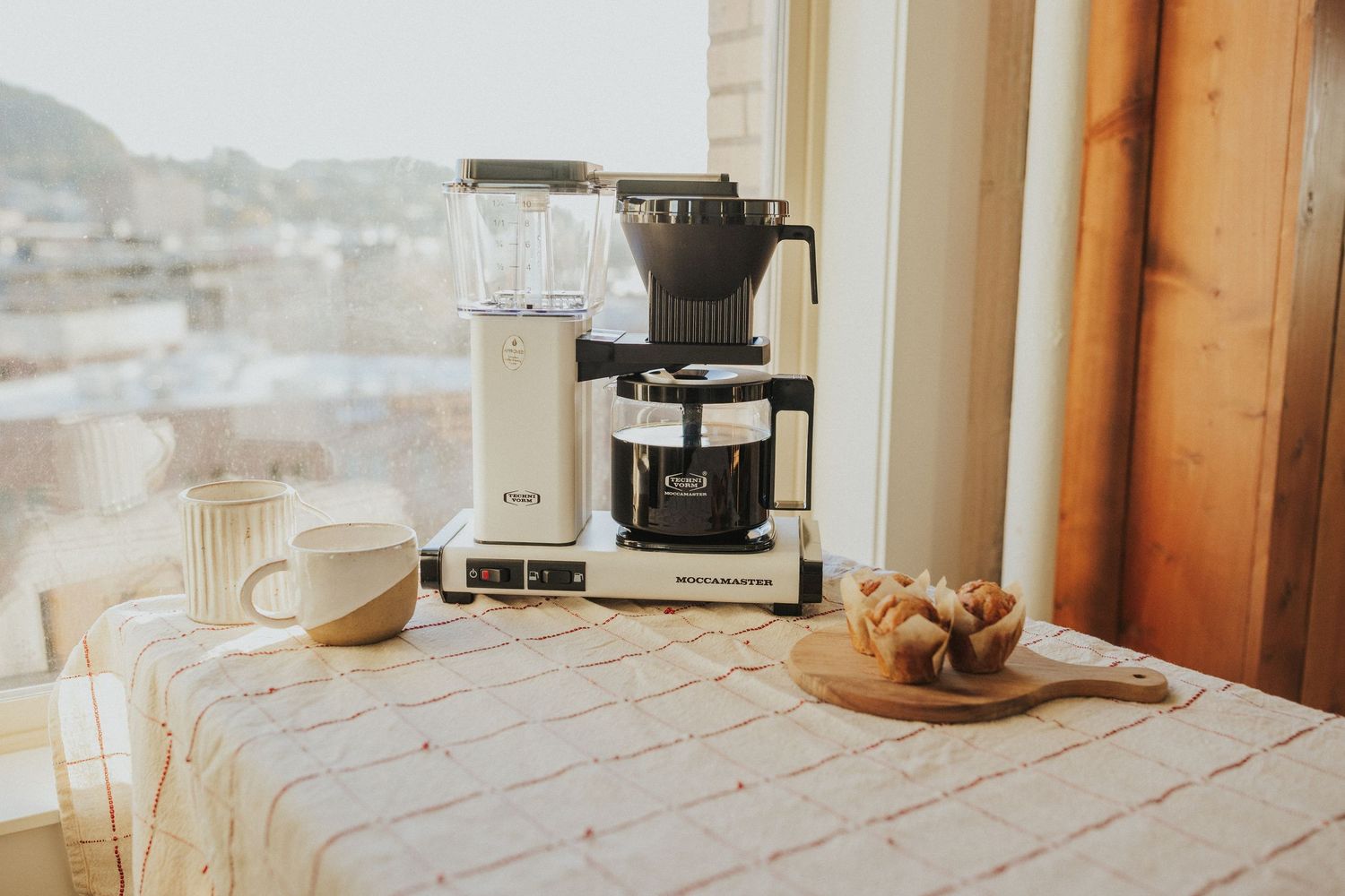 Coffee brewing station with wooden elements and natural light streaming through windows.