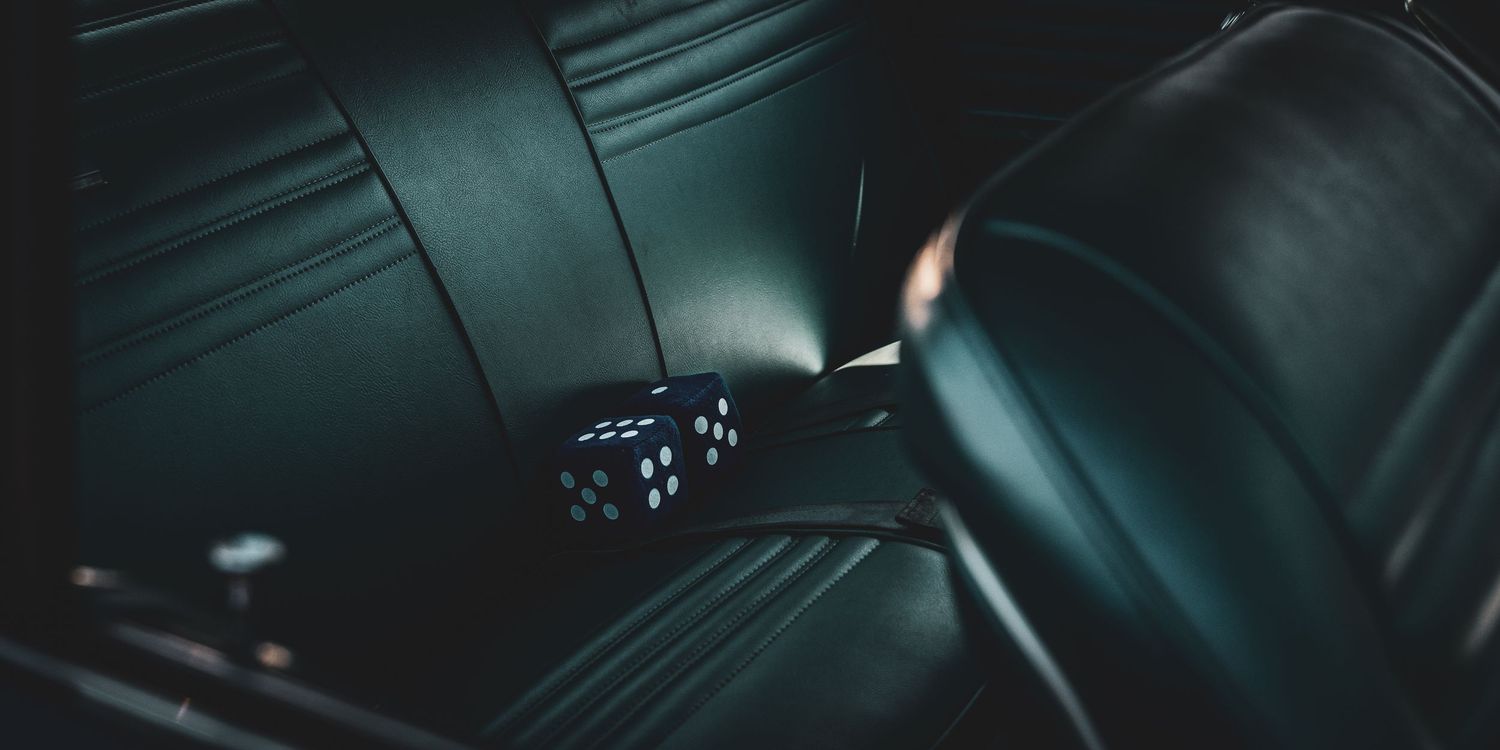 Dark car interior dashboard illuminated with blue ambient lighting showing modern digital displays and controls.