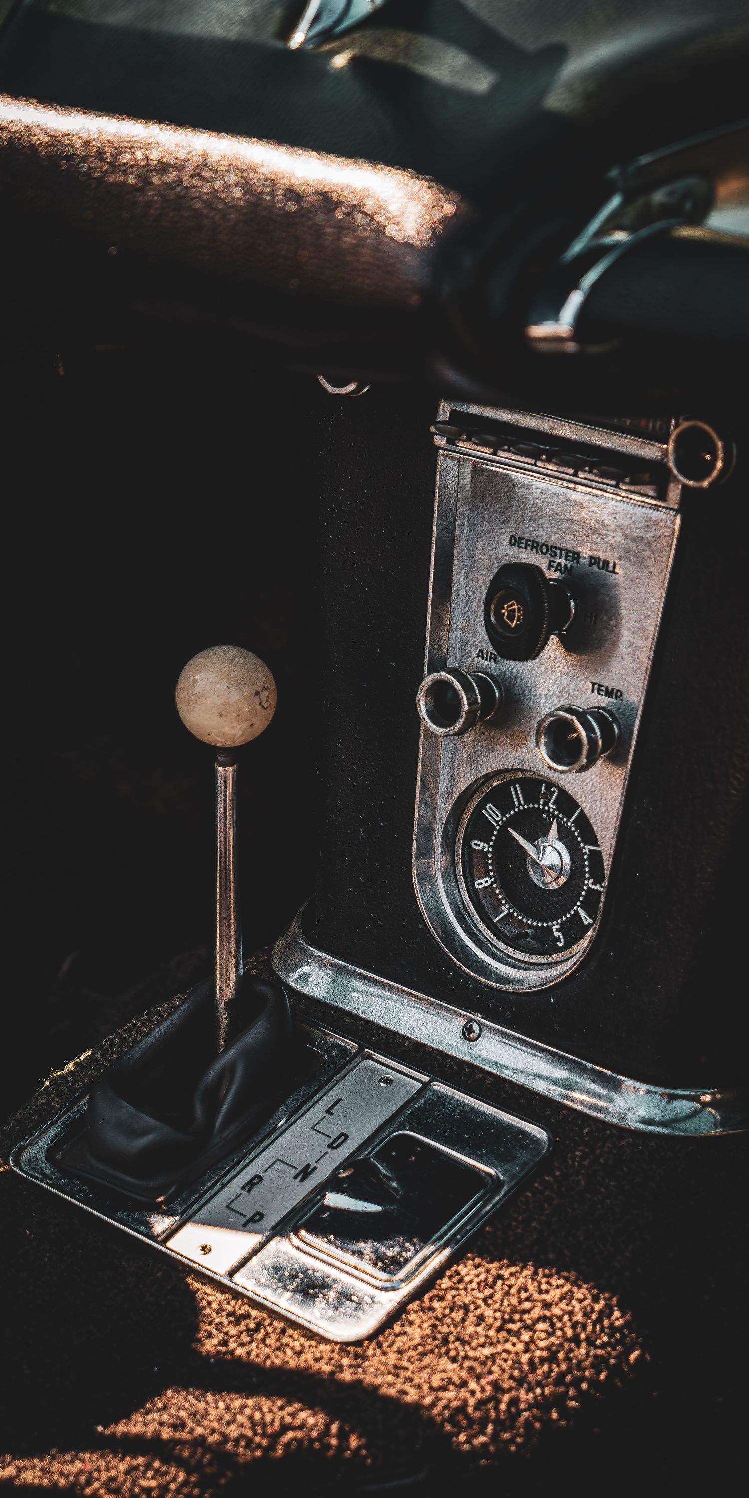 Vintage car clock gauges surrounded by coffee beans in dramatic low-key lighting creating an artistic composition.