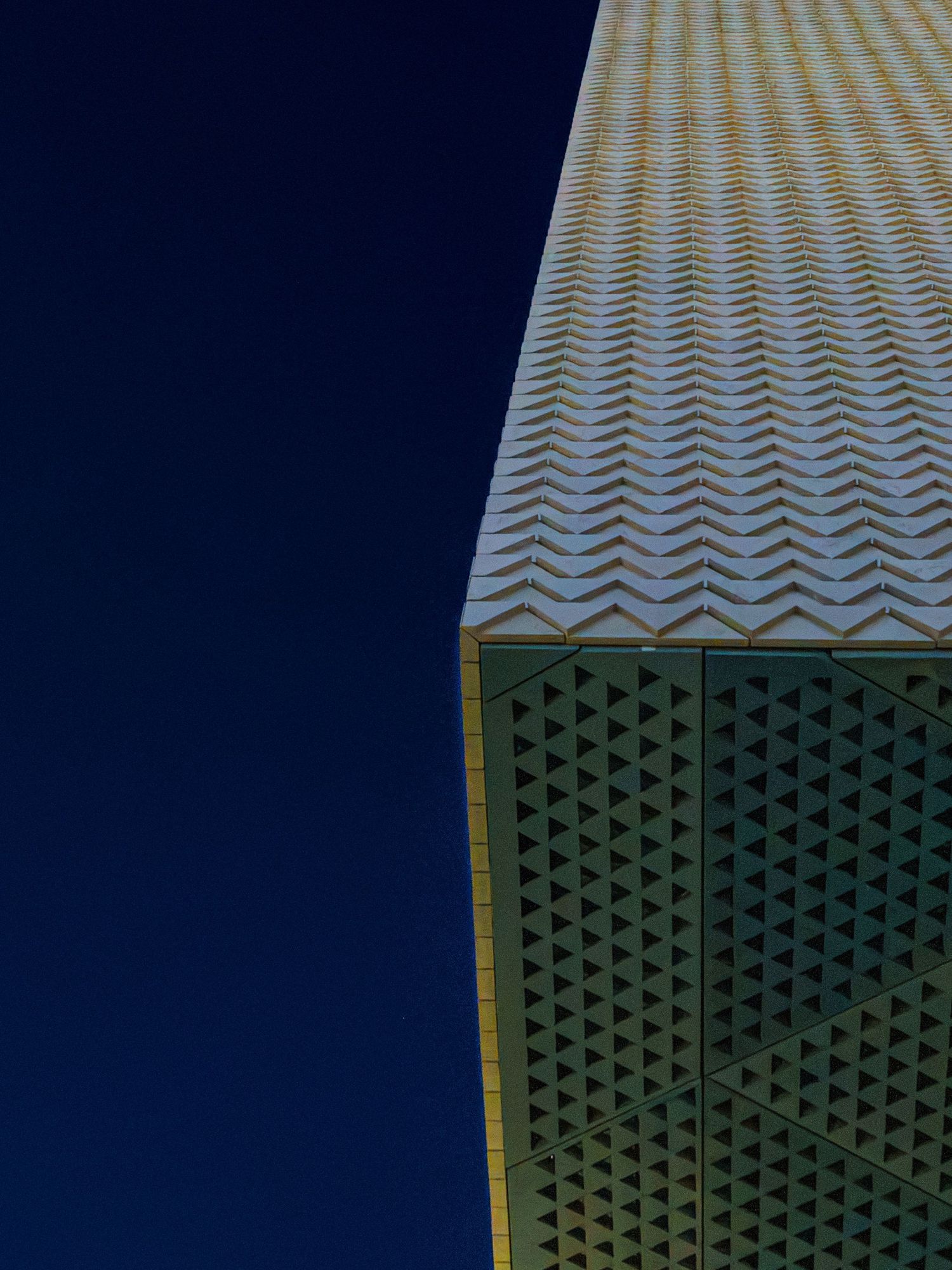 Architectural detail showing a pattern of triangular shapes and lines on a modern building facade.