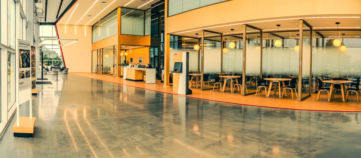 Modern office building interior with orange walls and glass partitions features sleek minimalist design and open layout.