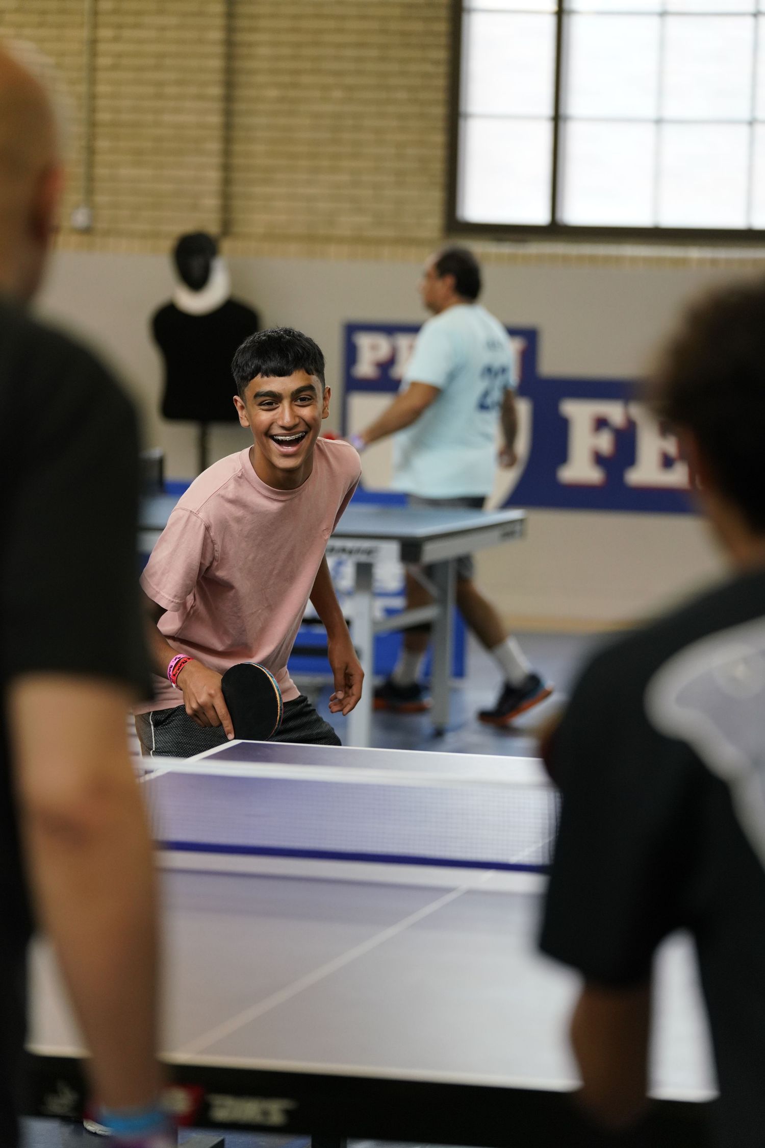 Players enjoying a competitive table tennis match in an indoor recreational facility.
