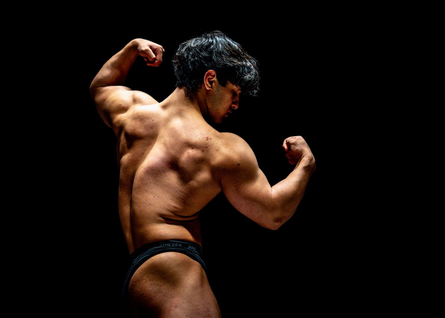 A sequence of six dramatic black and white photos showing a muscular back and shoulders against a dark background.