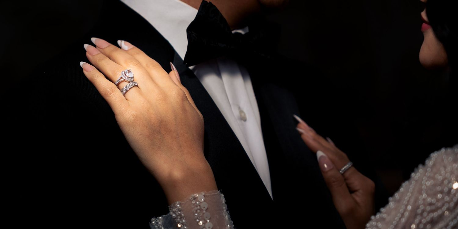 A close-up shot of hands exchanging wedding rings during a formal ceremony.