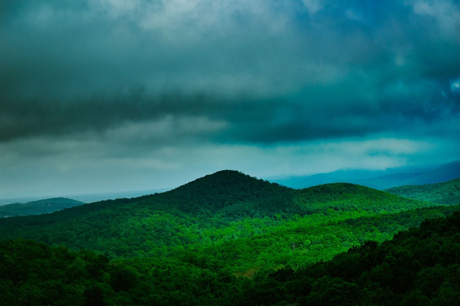 A series of panoramic landscape photos showing dramatic stormy skies over lush green mountains and hills.