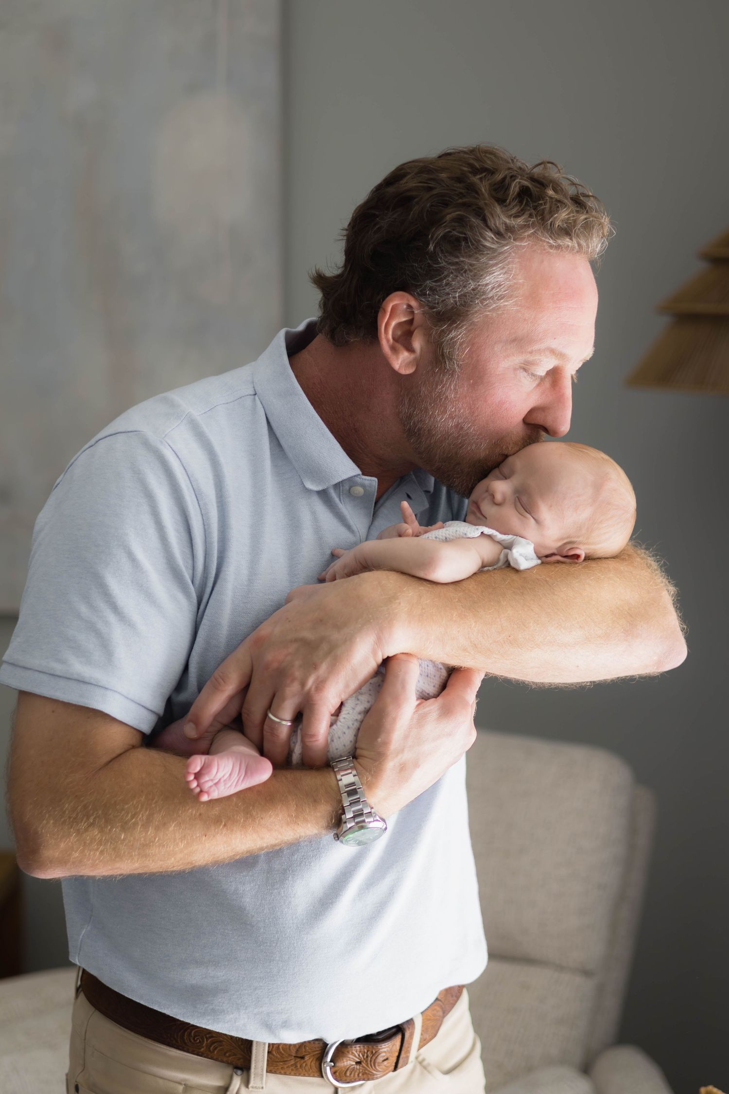 Dallas dad in natural light sweetly kisses his newborn son's forehead