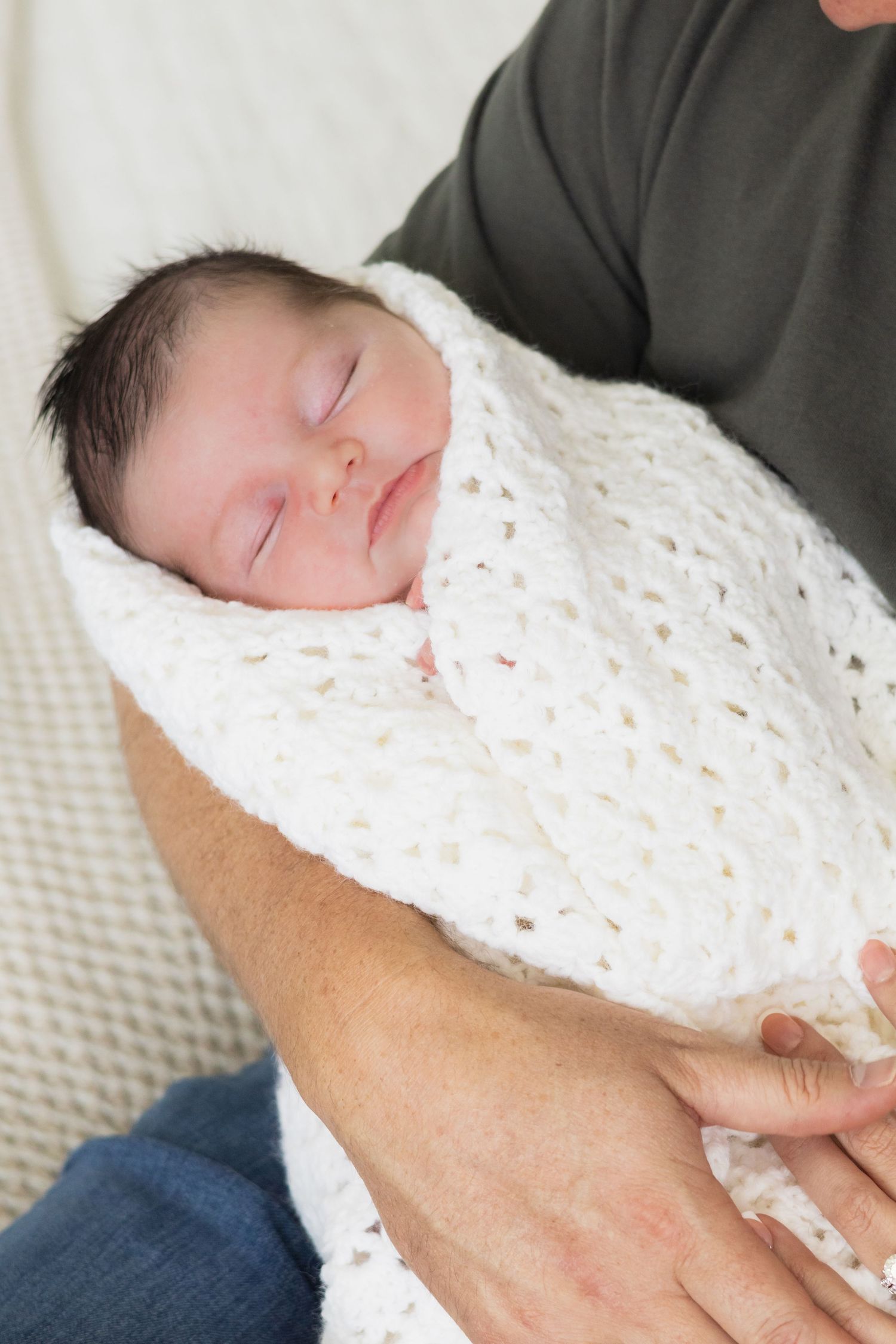 Bundled up baby is carefully cradled in new dad's arms