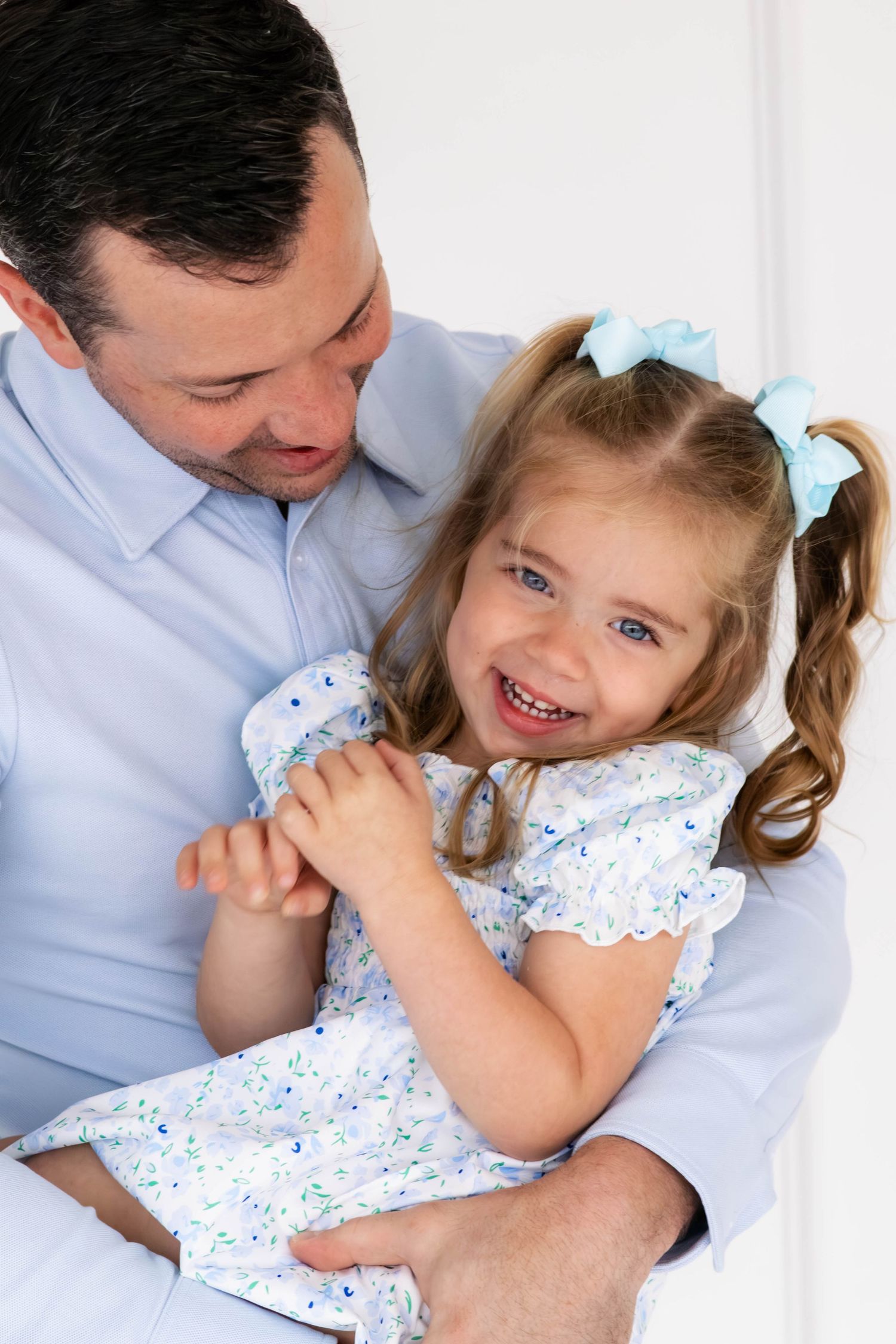 Daughter giggling in her dad's arms during a DFW studio session