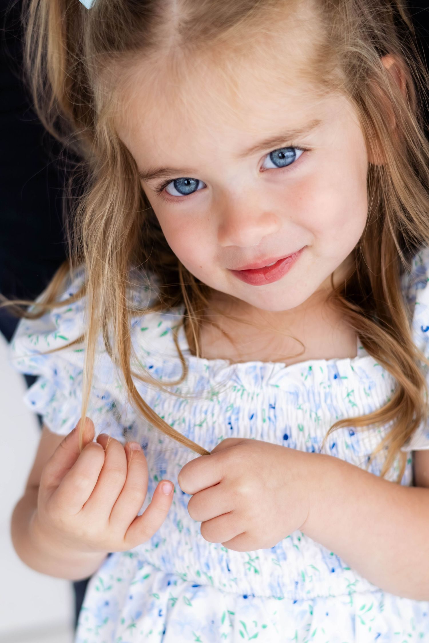 Toddler girl sweetly smiles at camera during a Dallas photography session