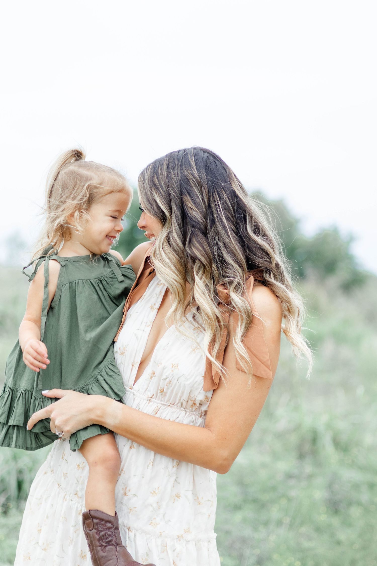 Mom holds daughter as they smile at each other