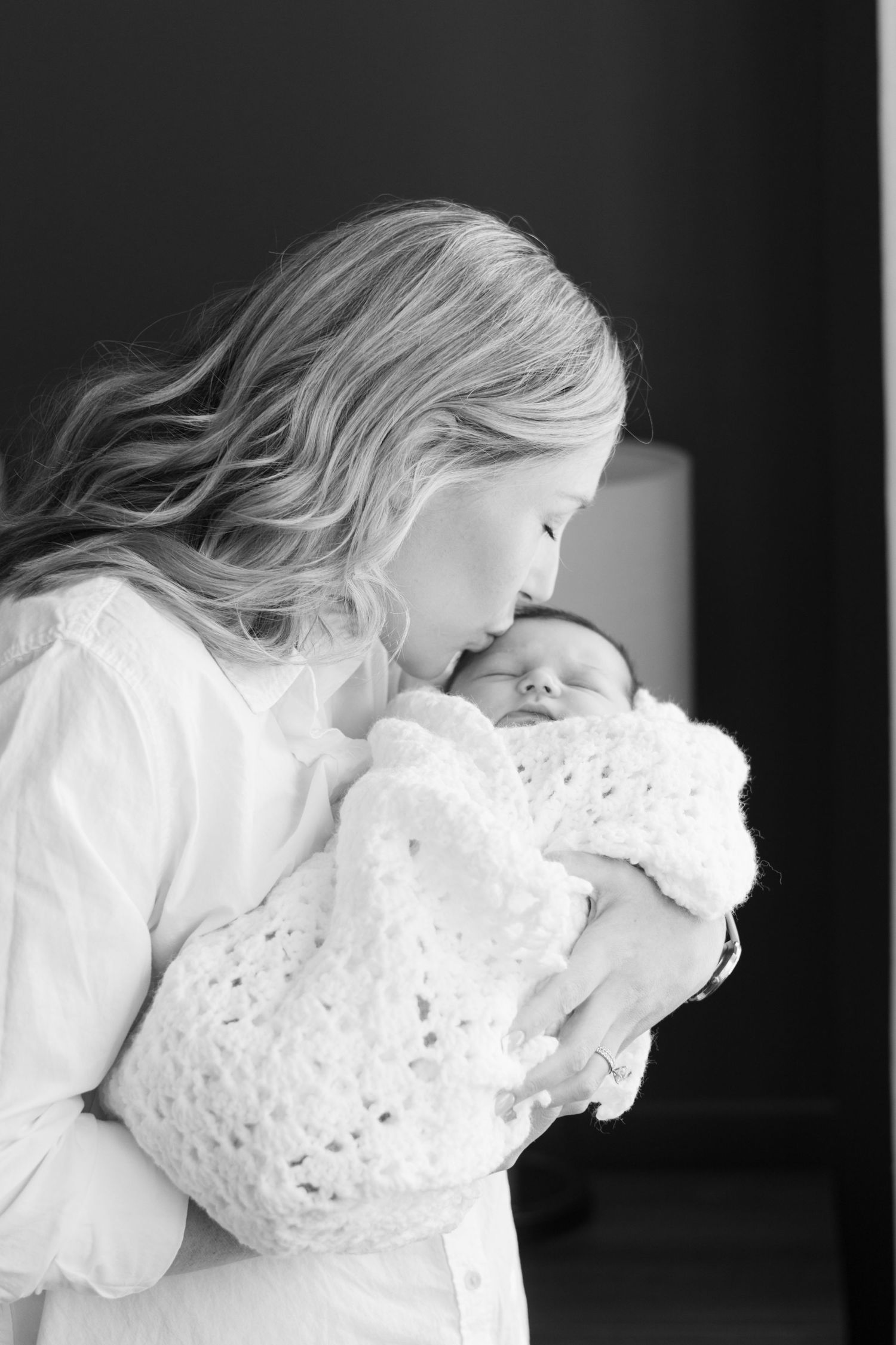 New mom sweetly kisses newborn's forehead
