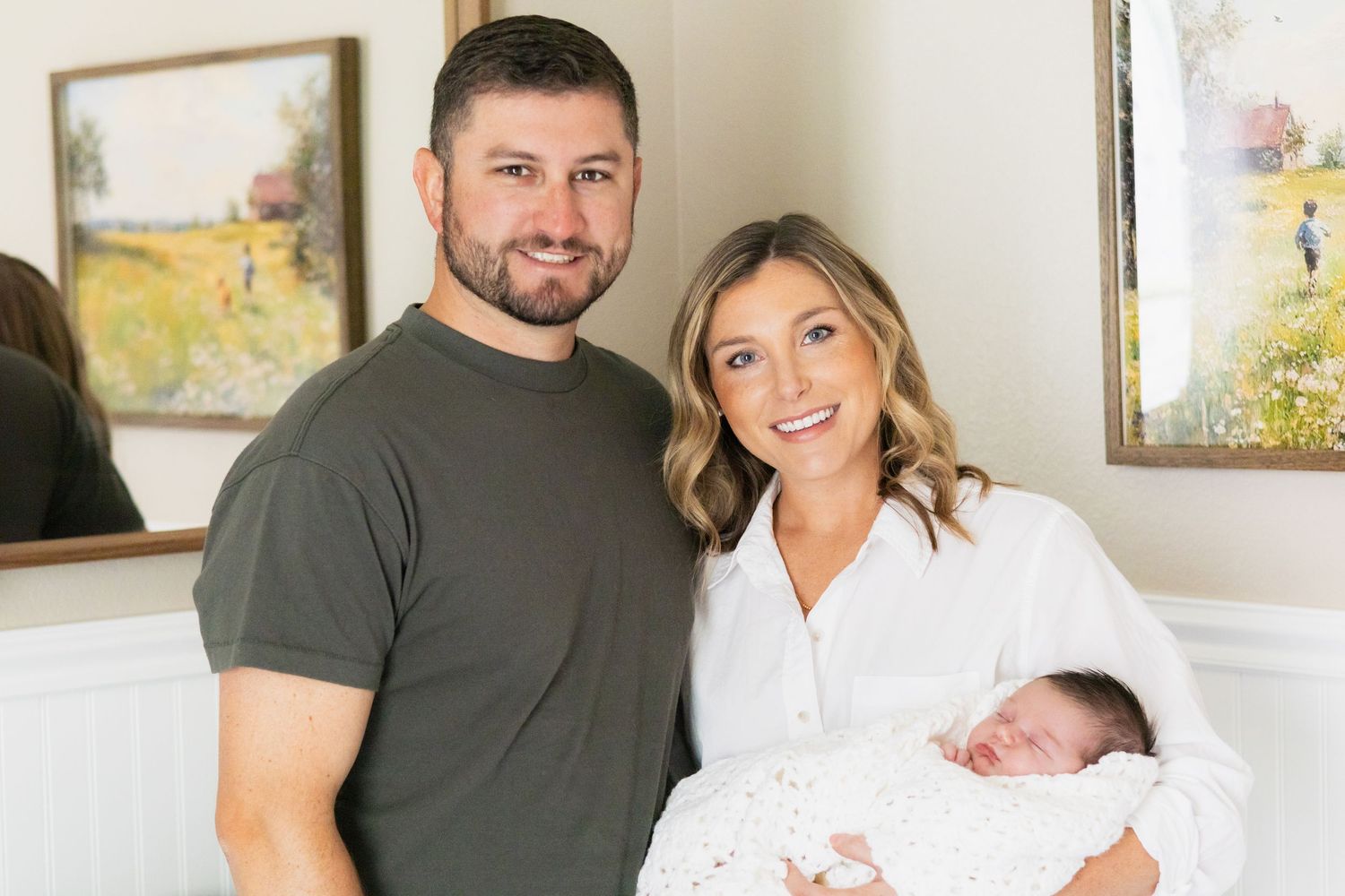 New Dallas parents proudly hold baby and smile at the camera