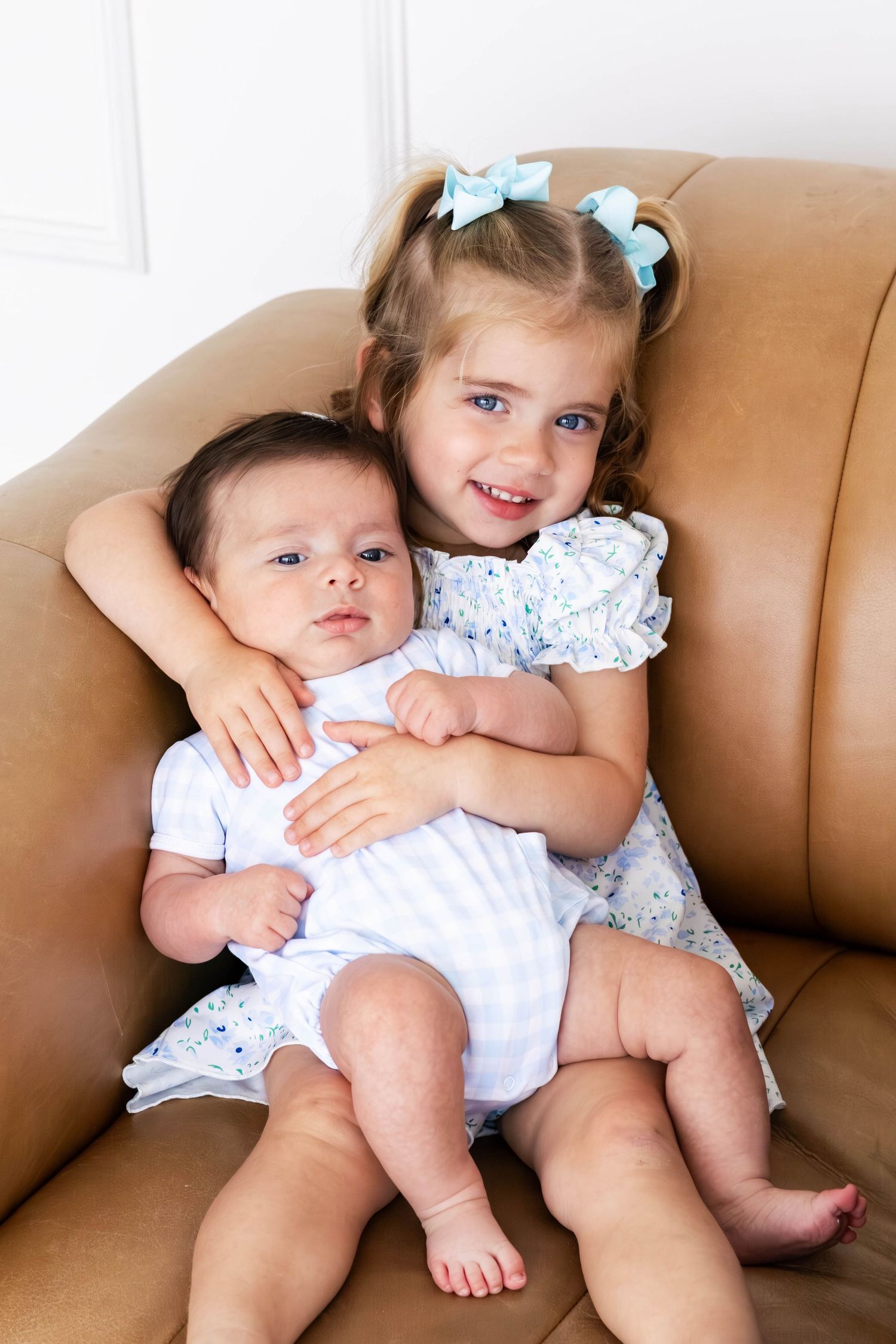 Big sister holding baby during a Dallas family studio session