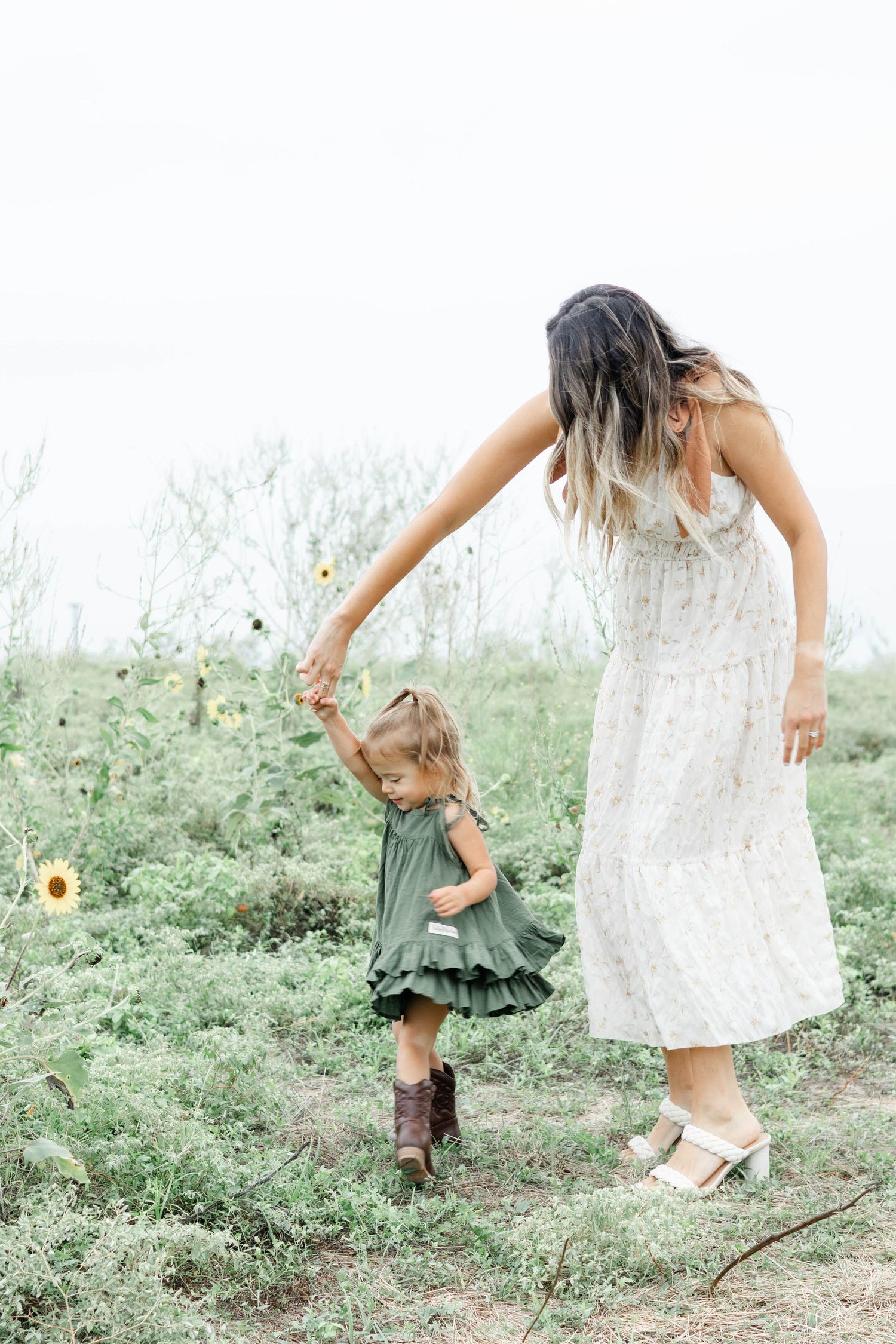 Mom and daughter spin and dance in a wild flower field at Arbor Hills Nature Preserve in Plano, Texas