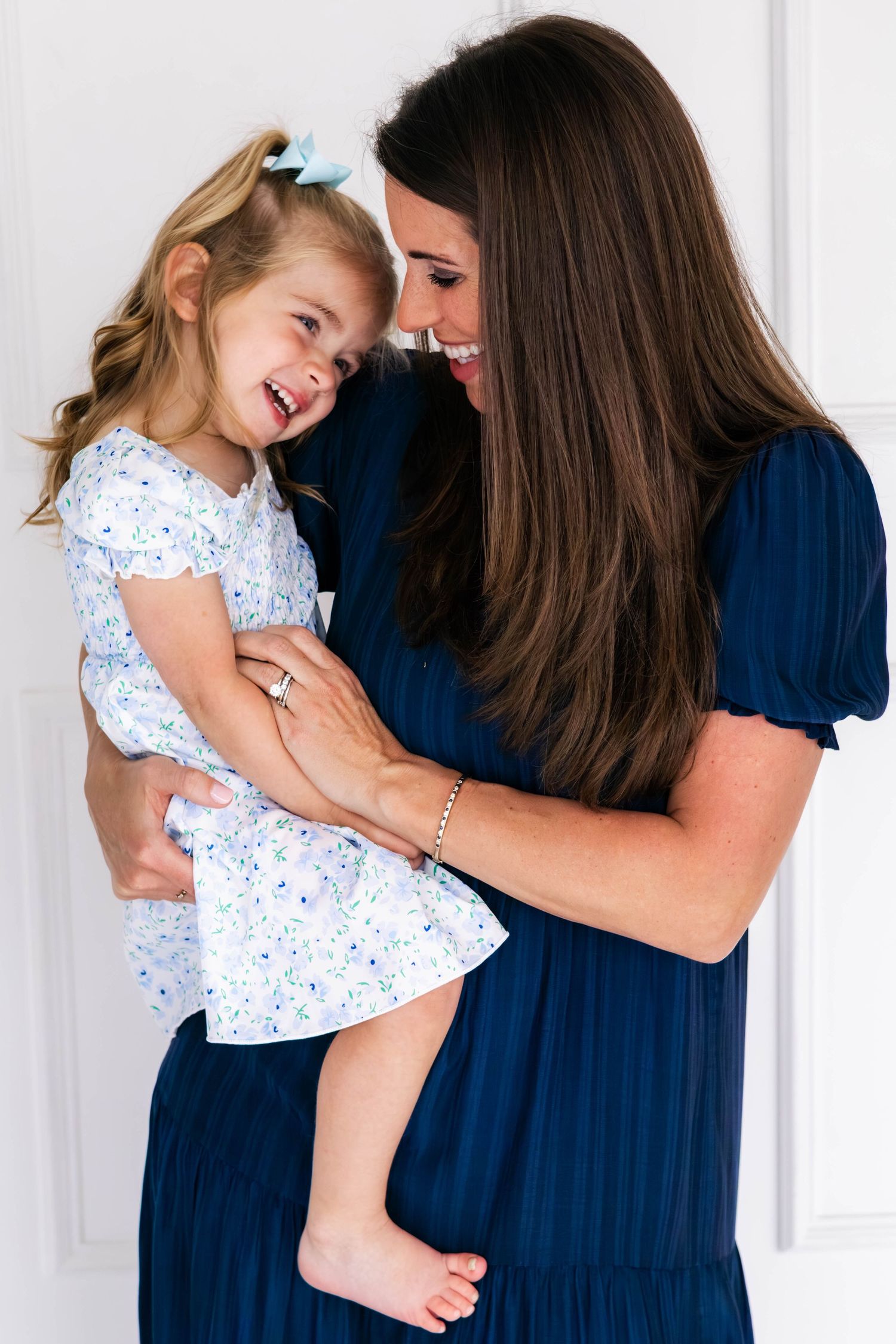 Mom tickles daughter playfully at a Dallas family photo shoot