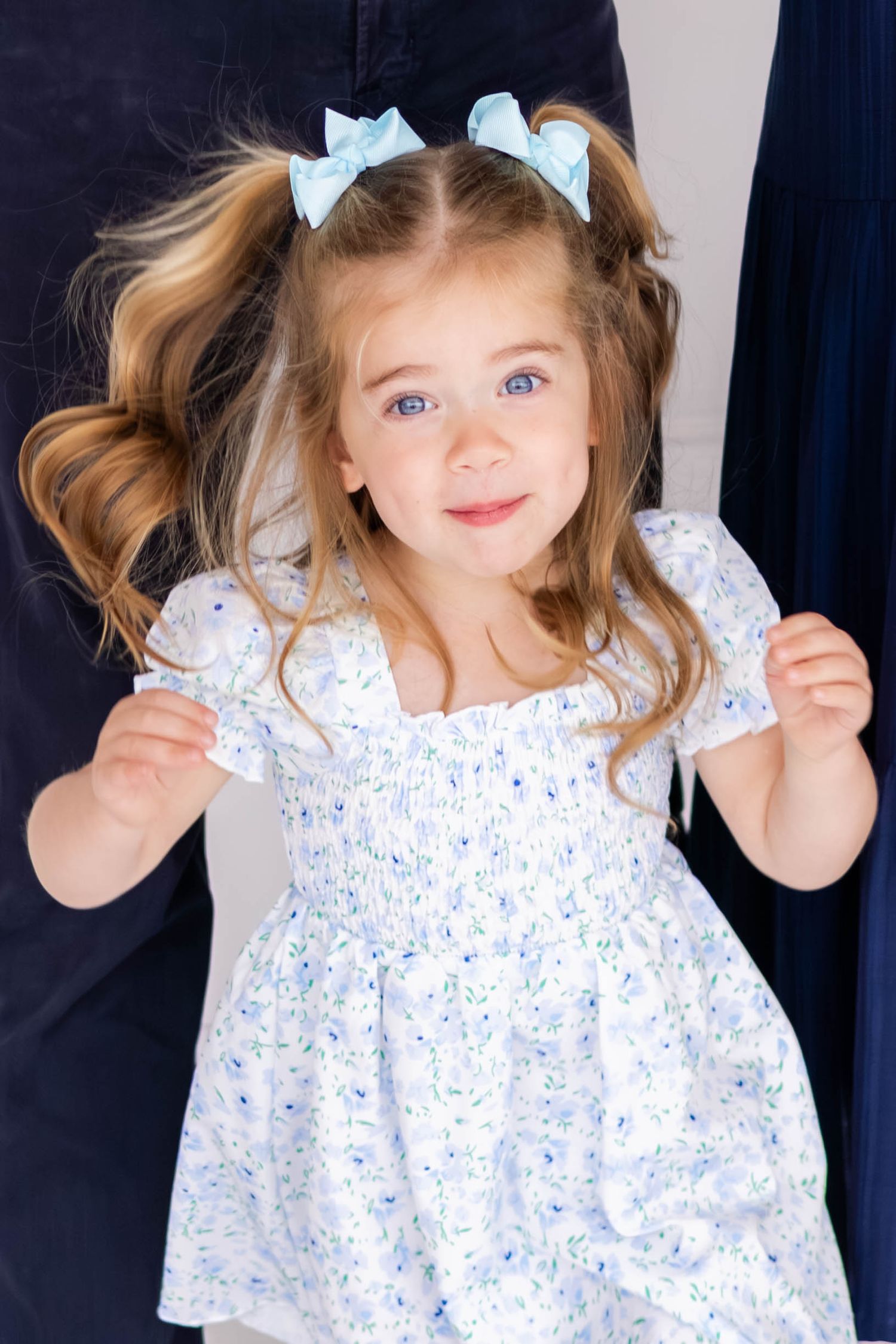 Toddler girl jumps gleefully in a family photography shoot