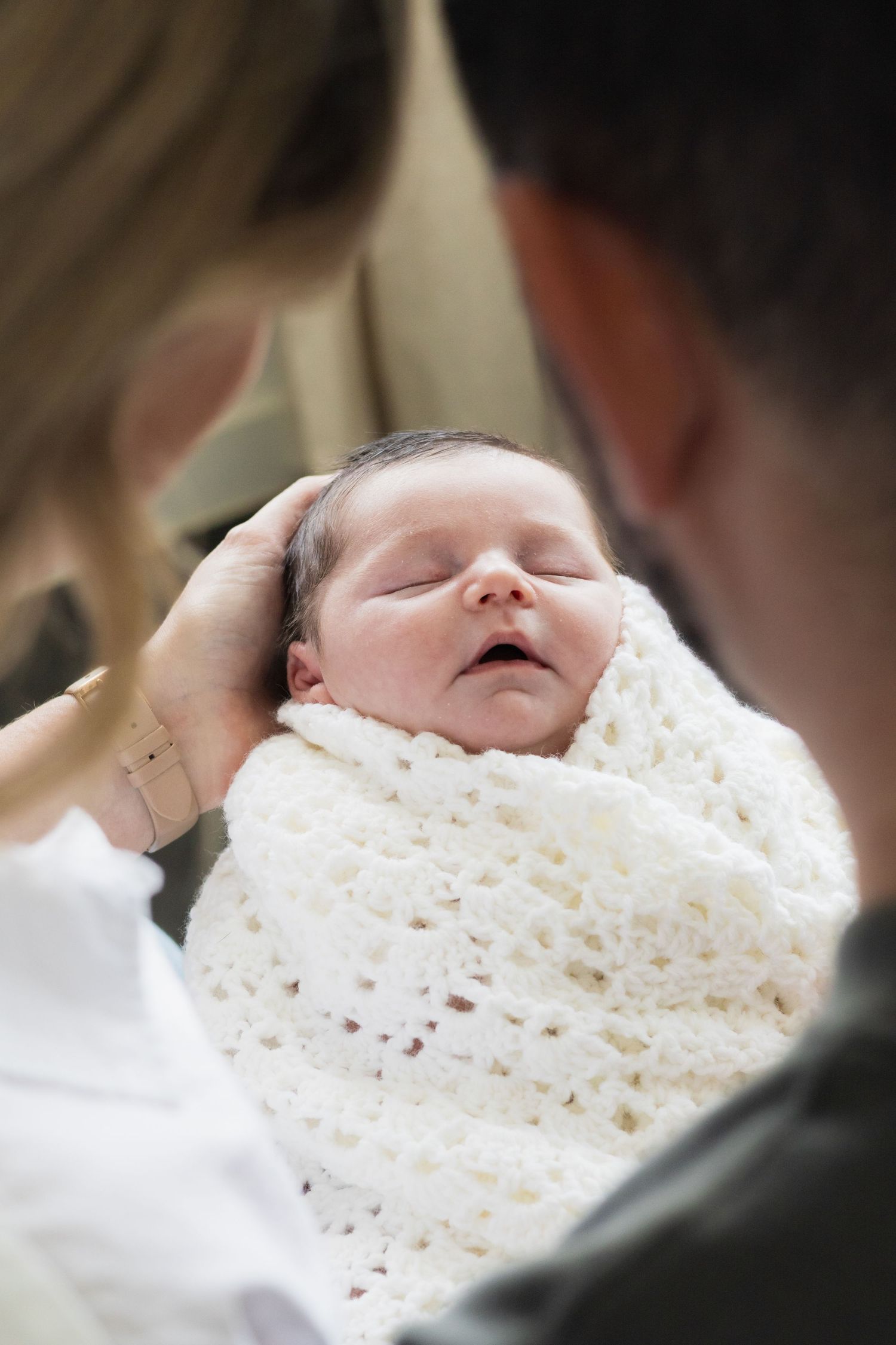 New parents hold son and admire him during DFW newborn photography session