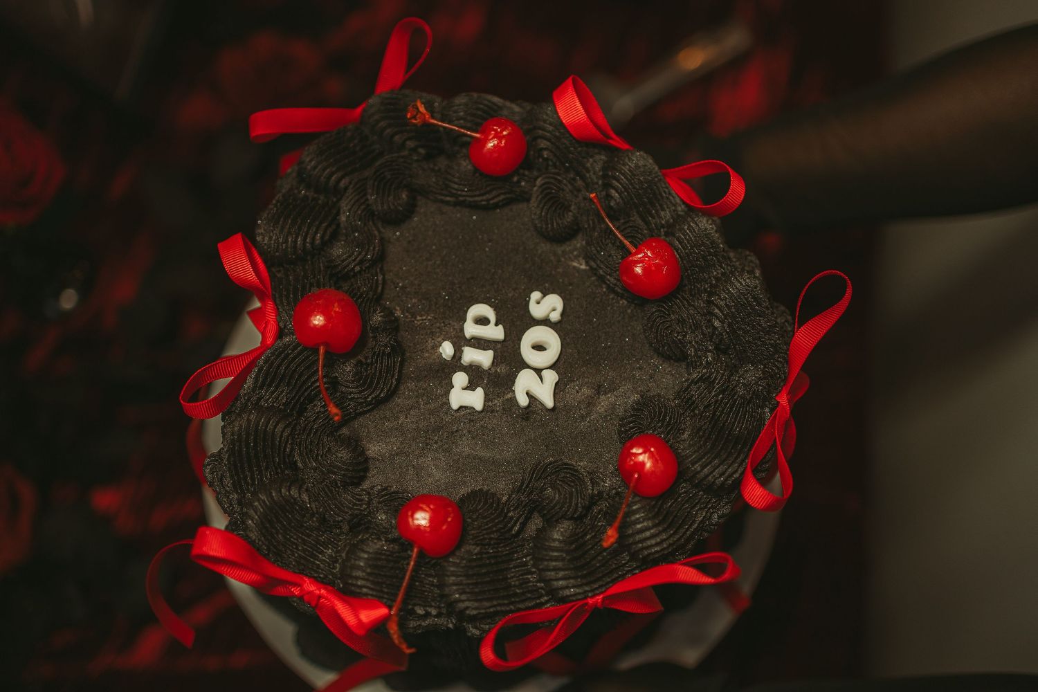Black and red birthday cake with ribbons