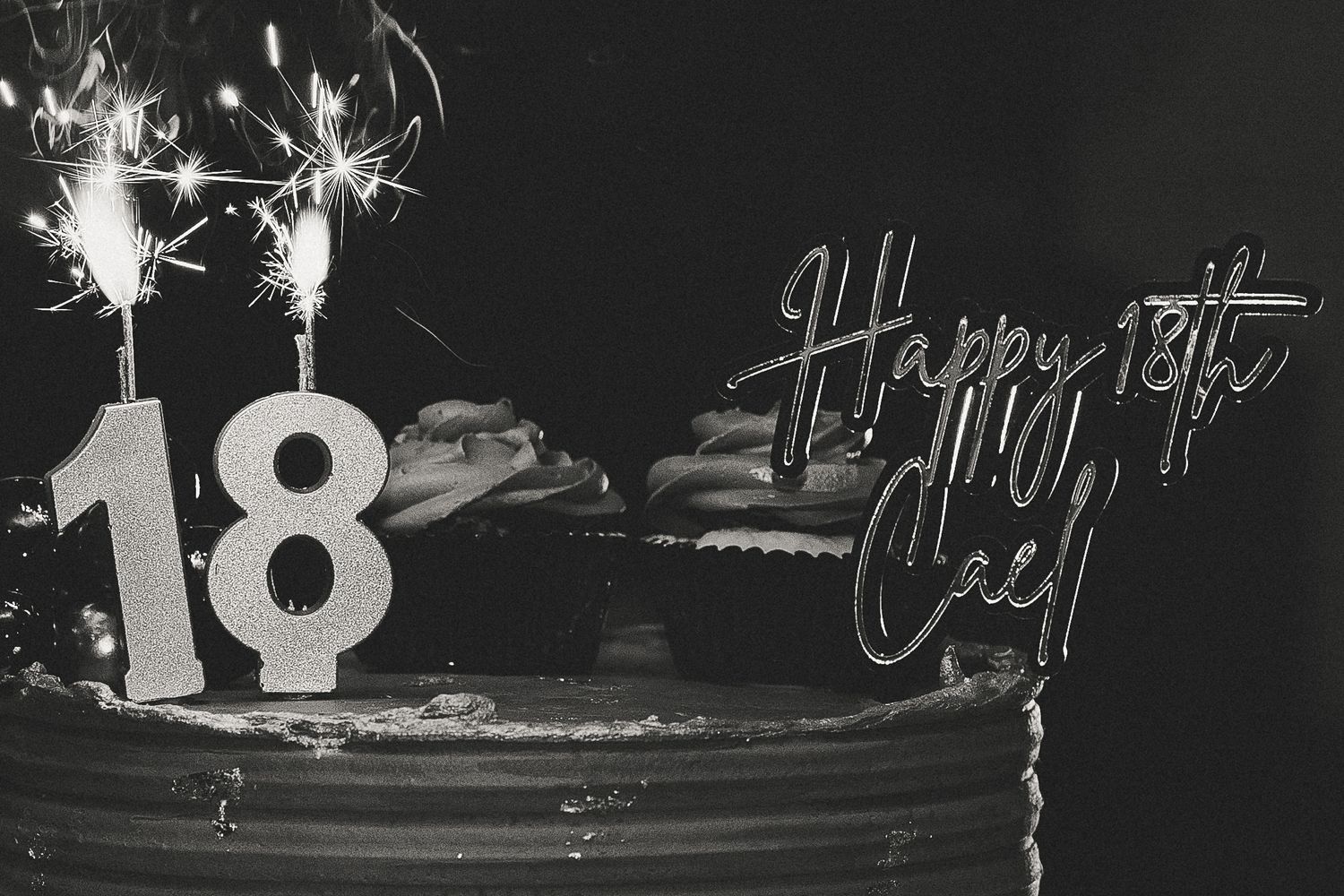 Sparklers creating bright light trails against a dark background at a celebration.