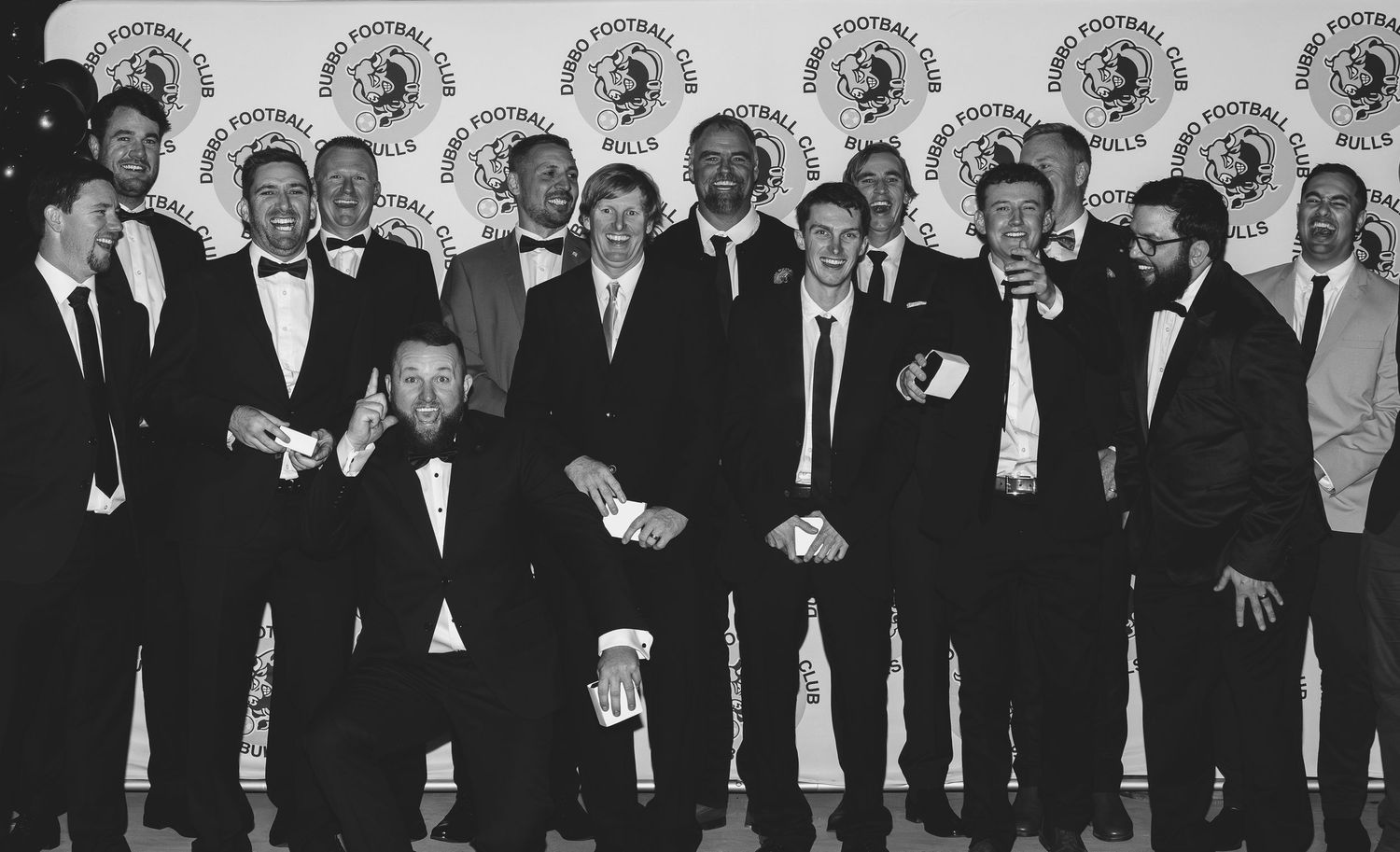 Black and white group photo of formally dressed people standing in a line.